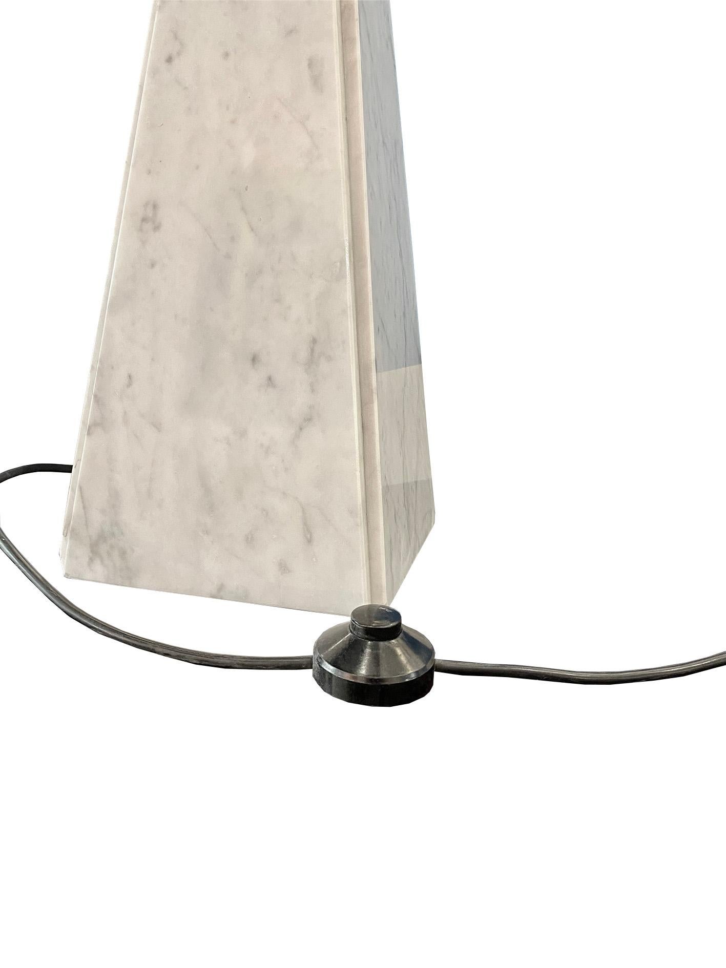 The Cini Boeri white marble and brass 'Abat-Jour' table lamp, a creation for Arteluce, is a true embodiment of refined design, showcasing the fusion of luxurious materials, sculptural aesthetics, and the art of illumination. Crafted by the visionary