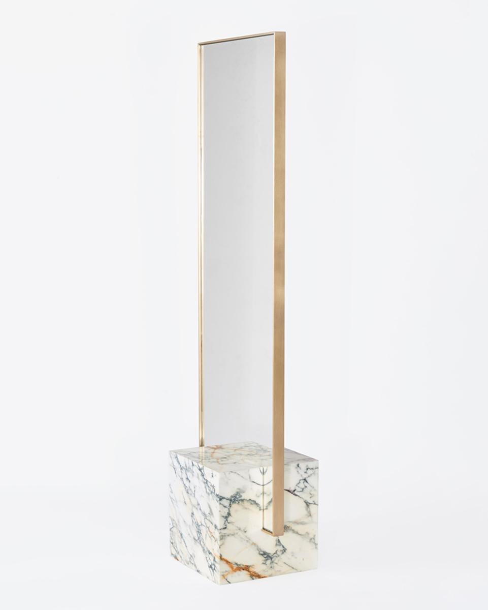 Le miroir sur pied coexist se compose d'une base cubique en marbre blanc, d'un cadre de miroir en laiton poli et de caoutchouc recyclé.

Le miroir encadré de laiton s'insère avec précision dans une base cubique en marbre richement veiné. La pièce