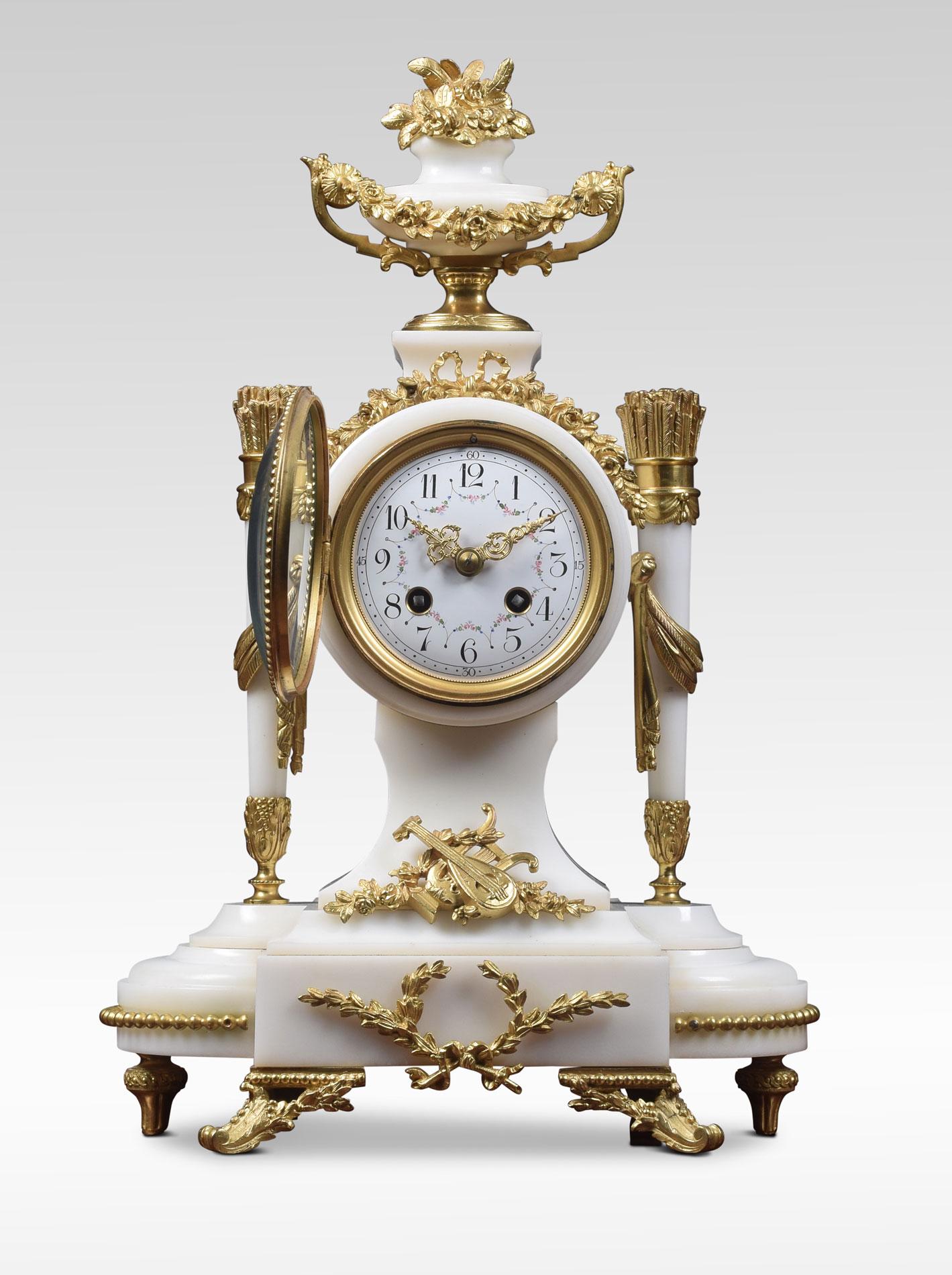White marble and gilt metal mounted clock set. The clock surmounted with urn above a 4-inch white enamel dial with scrolling flowers and numerals. The two train movement striking a bell. Flanked by circular tapered columns raised up on a shaped