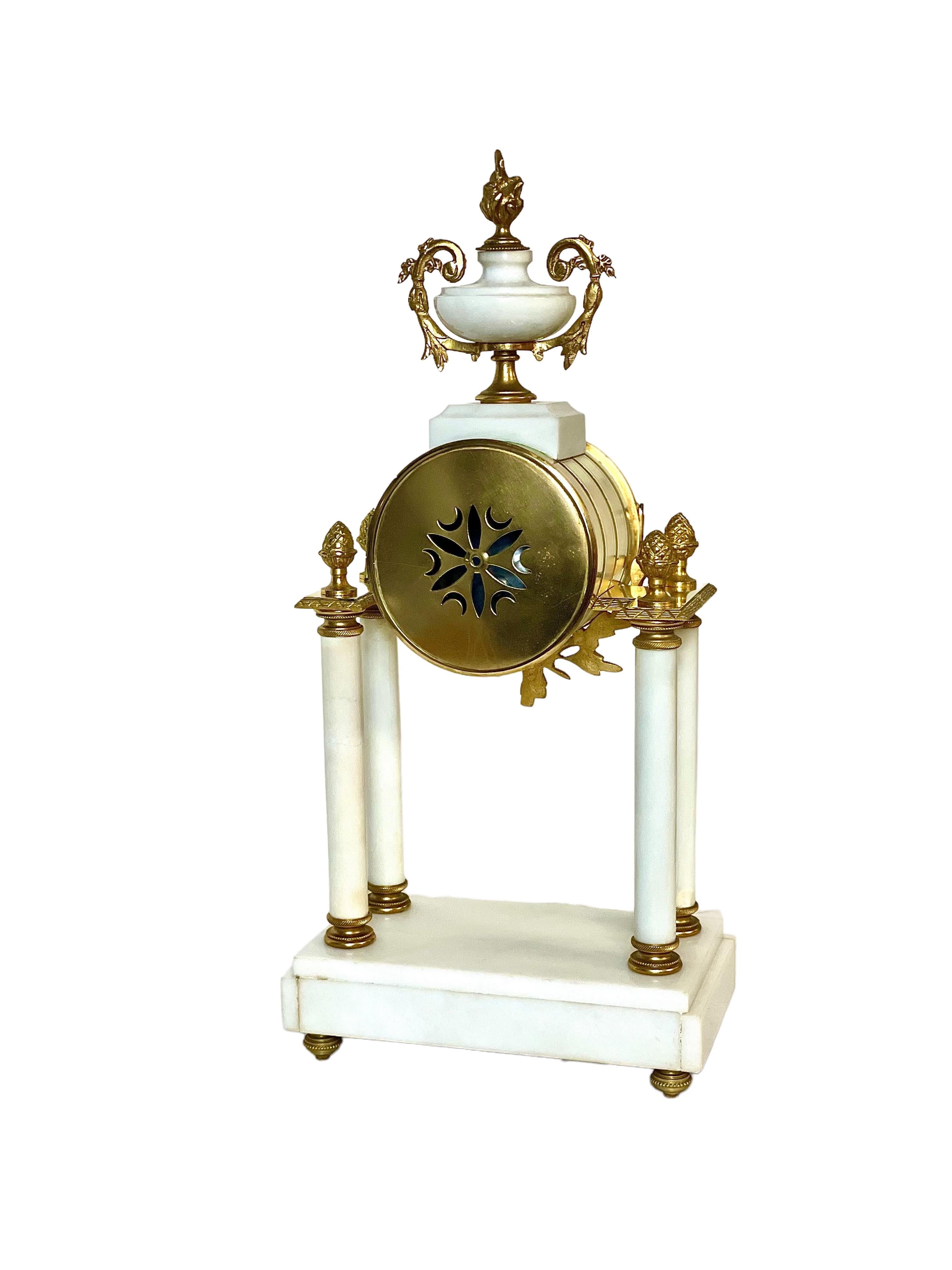 Une belle et originale horloge de portique française ancienne, fabriquée en marbre blanc monté avec du bronze doré. Le cadran de l'horloge est délicatement peint avec des guirlandes florales entre les chiffres sur de l'émail de porcelaine, et est