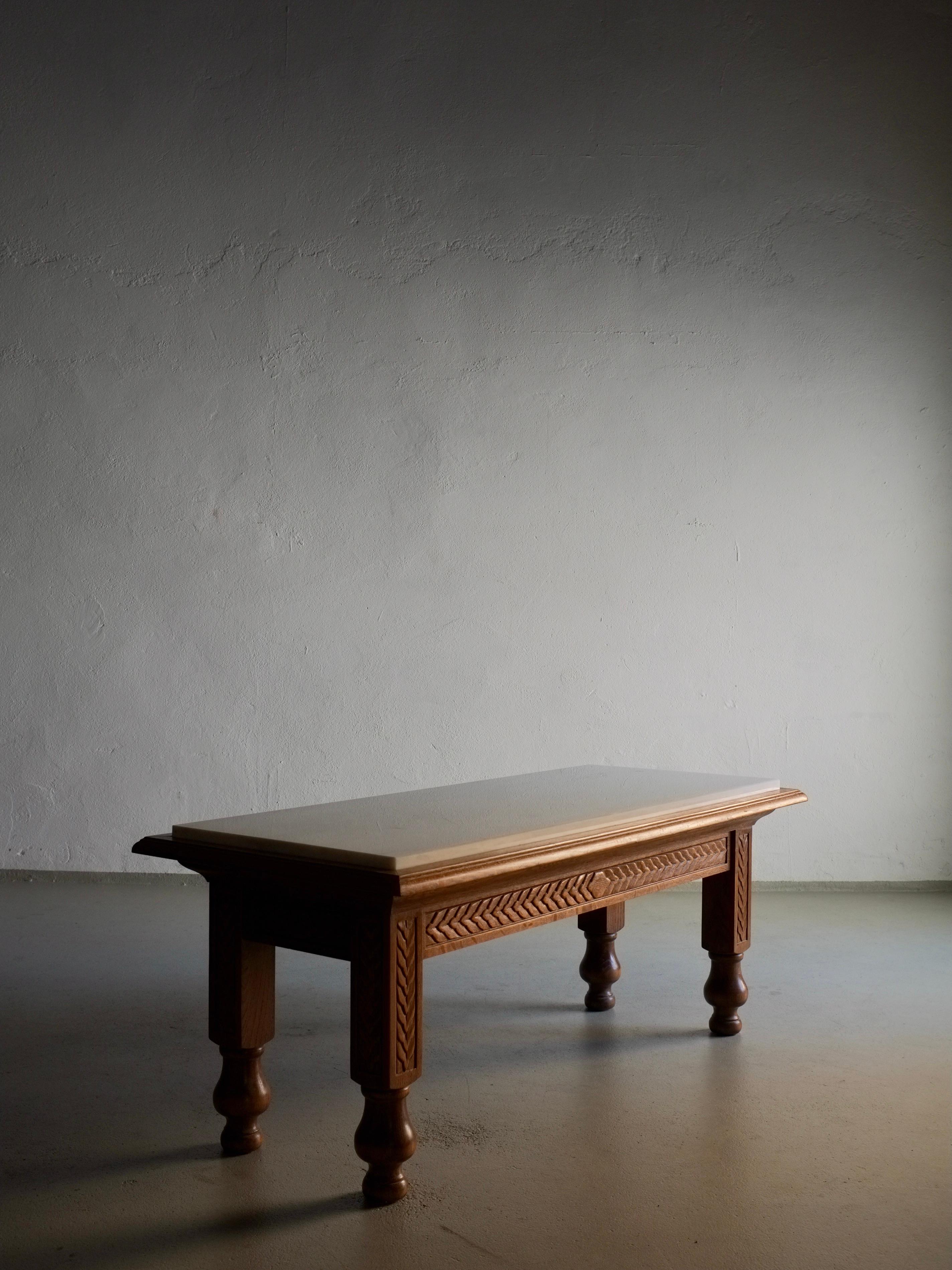 Geschnitzter Couchtisch aus Eichenholz mit einer Tischplatte aus weißem Marmor. Ein gewichtiger Gegenstand.