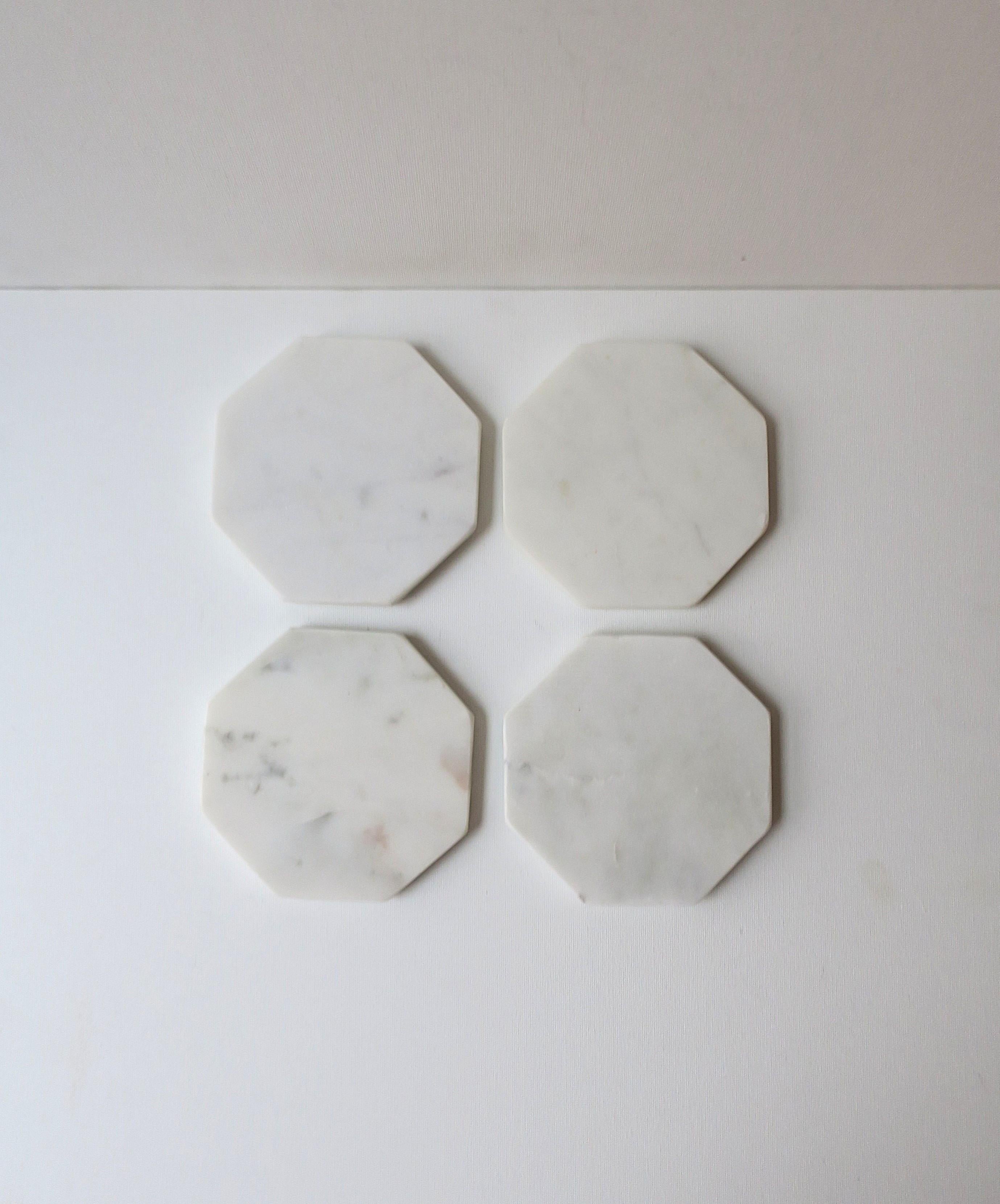 A set of four (4) white marble cocktail drinks coasters, in the modern style. A great set with an octagonal shape, light veining, and round white protectives on bottom. Perfect for drinks, cocktails, champagne, etc. A great addition to any bar or