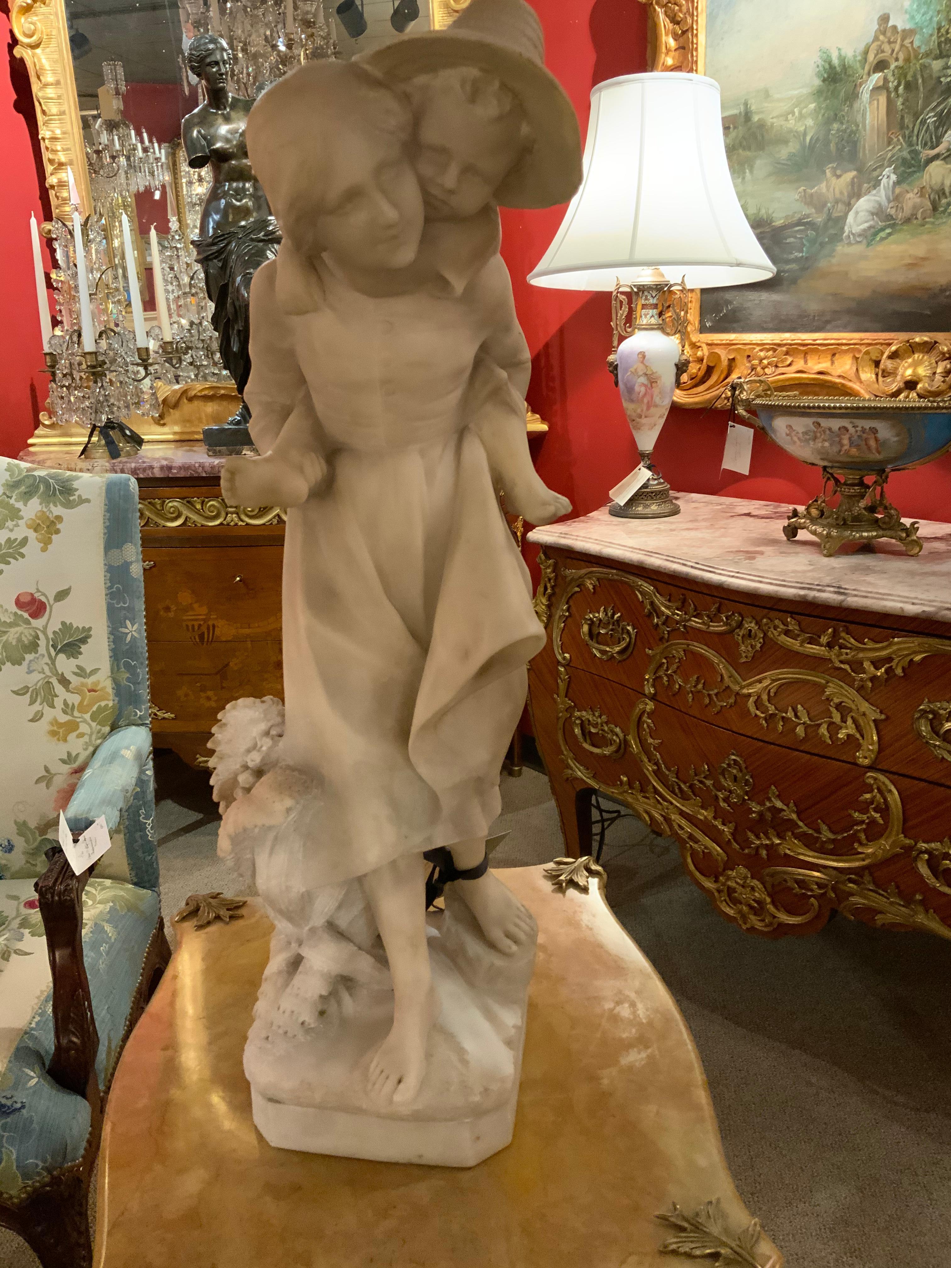 Well sculpted white marble statue by the artist Viviana. It is signed on the center back base.
It has had a professional restoration to one toe that is shown in the photo. The mother is
Carrying the child on her back.