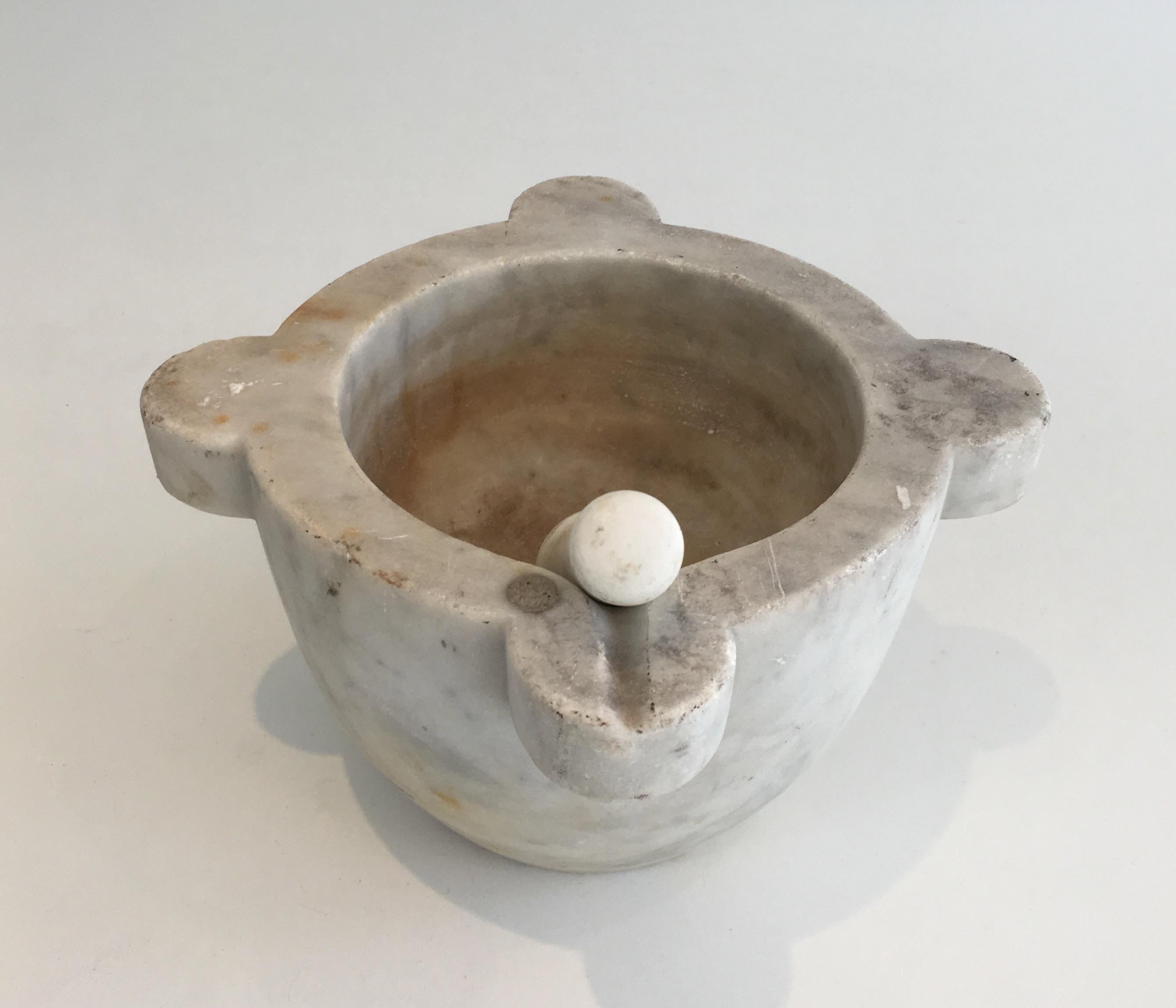 This mortar is made of white marble with a wooden pestle. This is a French work made in 18th century.