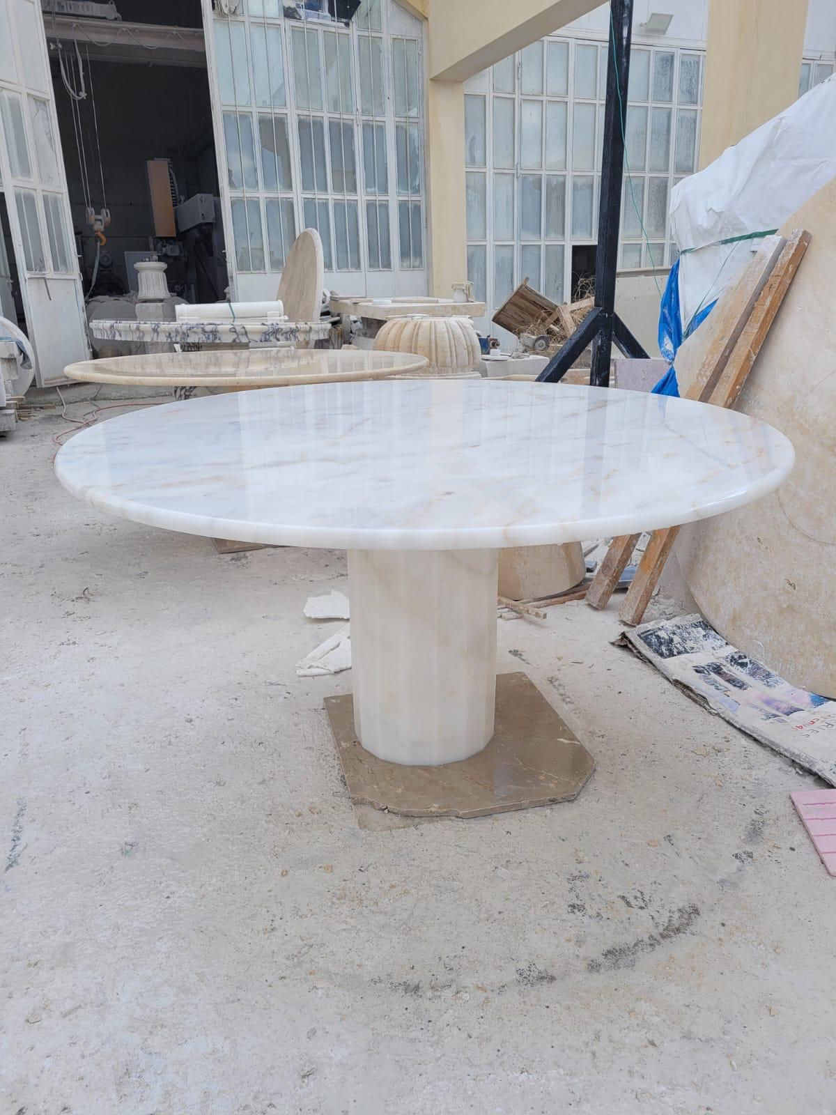 Dieser minimalistische Tisch aus weißem Marmor hat einen sechseckigen Fuß und eine runde Tischplatte aus Travertin, die durch ihr Eigengewicht perfekt und sicher balanciert. 

Funktionelles Stück mit Platz für Beinfreiheit.

Marmor ist nicht gleich