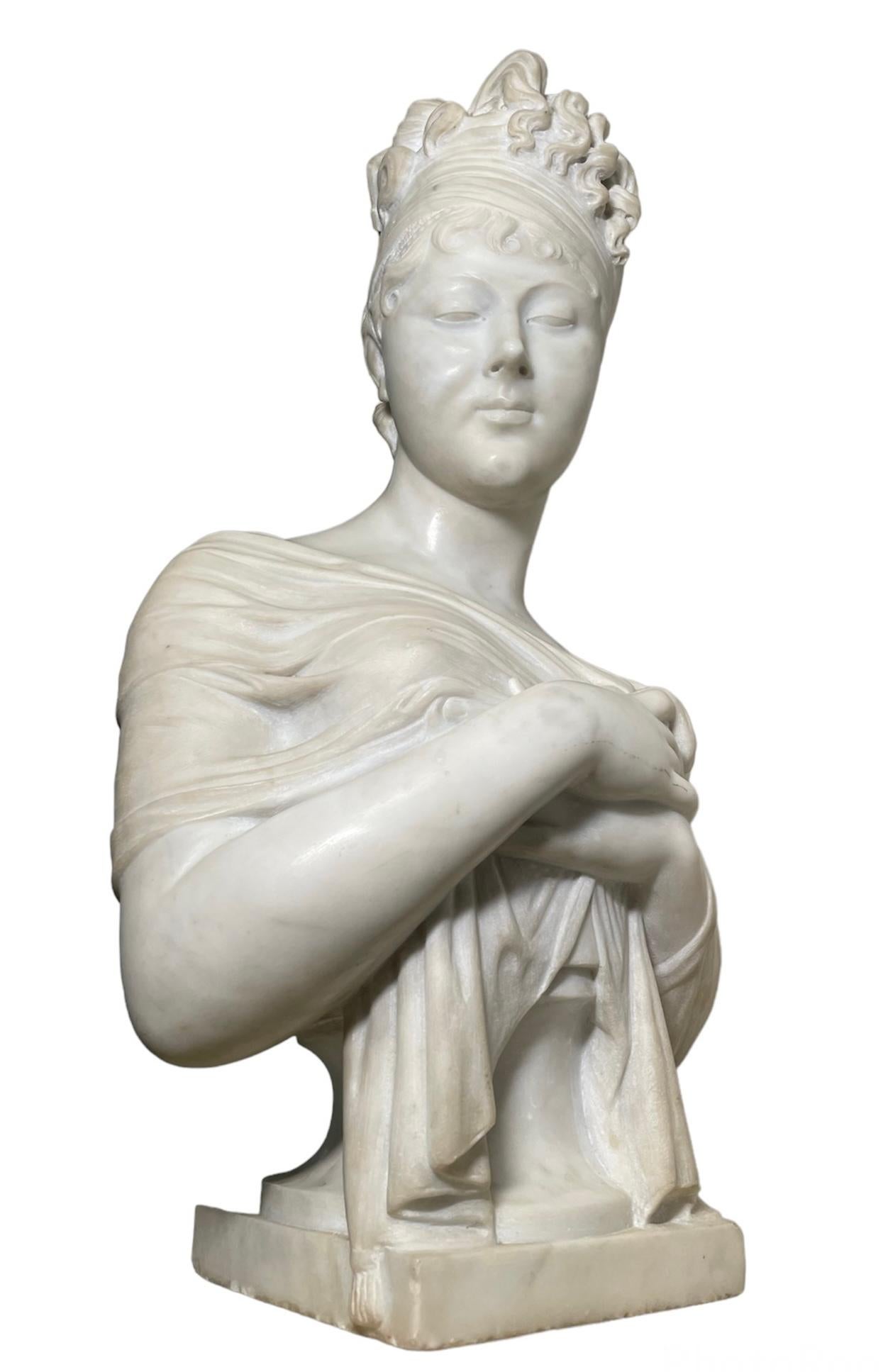 This is a white marble bust of Madame Recamier after Joseph Chinard sculpture. It depicts her head rotated to the right while she is covering her chest with a semi -transparent, probably silk shawl, but exposing one of her breast. She shows a shy