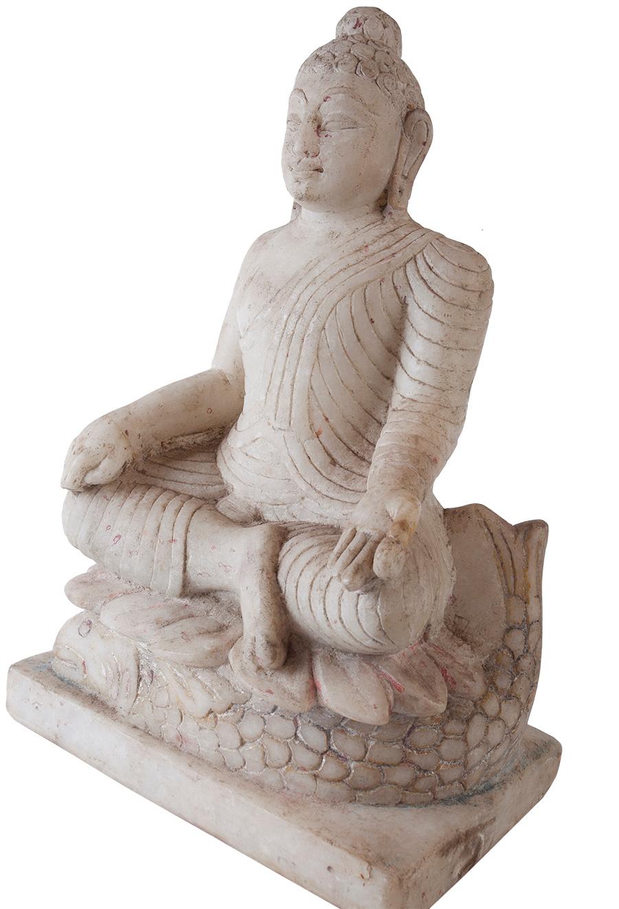 A lovely sitting Buddha in white marble. He sits on the lotus flower symbolic of purity and enlightenment and yet still connected to the grounding of the life connections below--the fish, the roots, the earth. The posture is the Bhumisparsha Mudra,