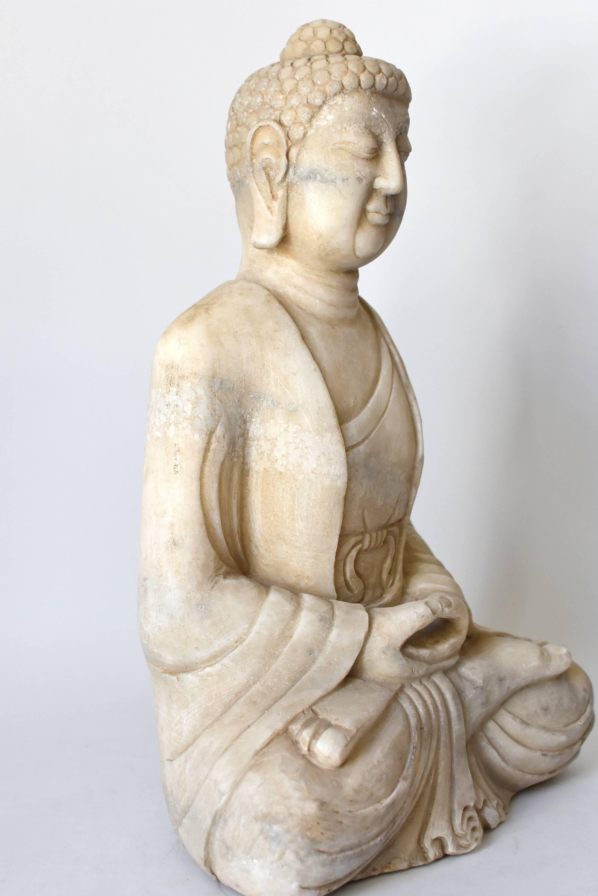 A beautiful Buddha statue hand-carved from solid marble. His facial expression and robe are well defined. Large earlobes and full face are features of Tang dynasty style. Buddha's special mudra with his fingers forming a circle expresses uniting the