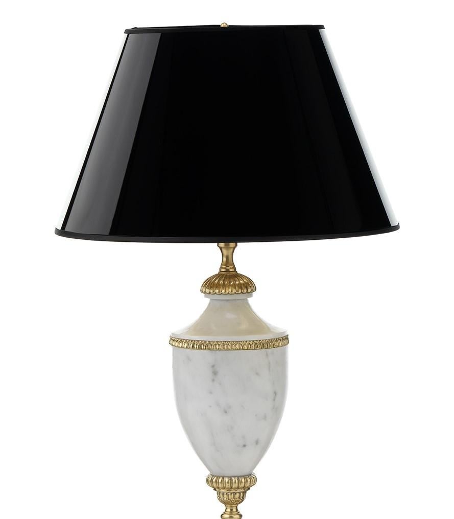 Pièce maîtresse d'un salon, d'un bureau ou d'une entrée, cette lampe de table dégage un charme néoclassique du 18e siècle. Reposant sur une base ronde, le corps audacieux, entièrement façonné en marbre blanc, présente une silhouette classique et