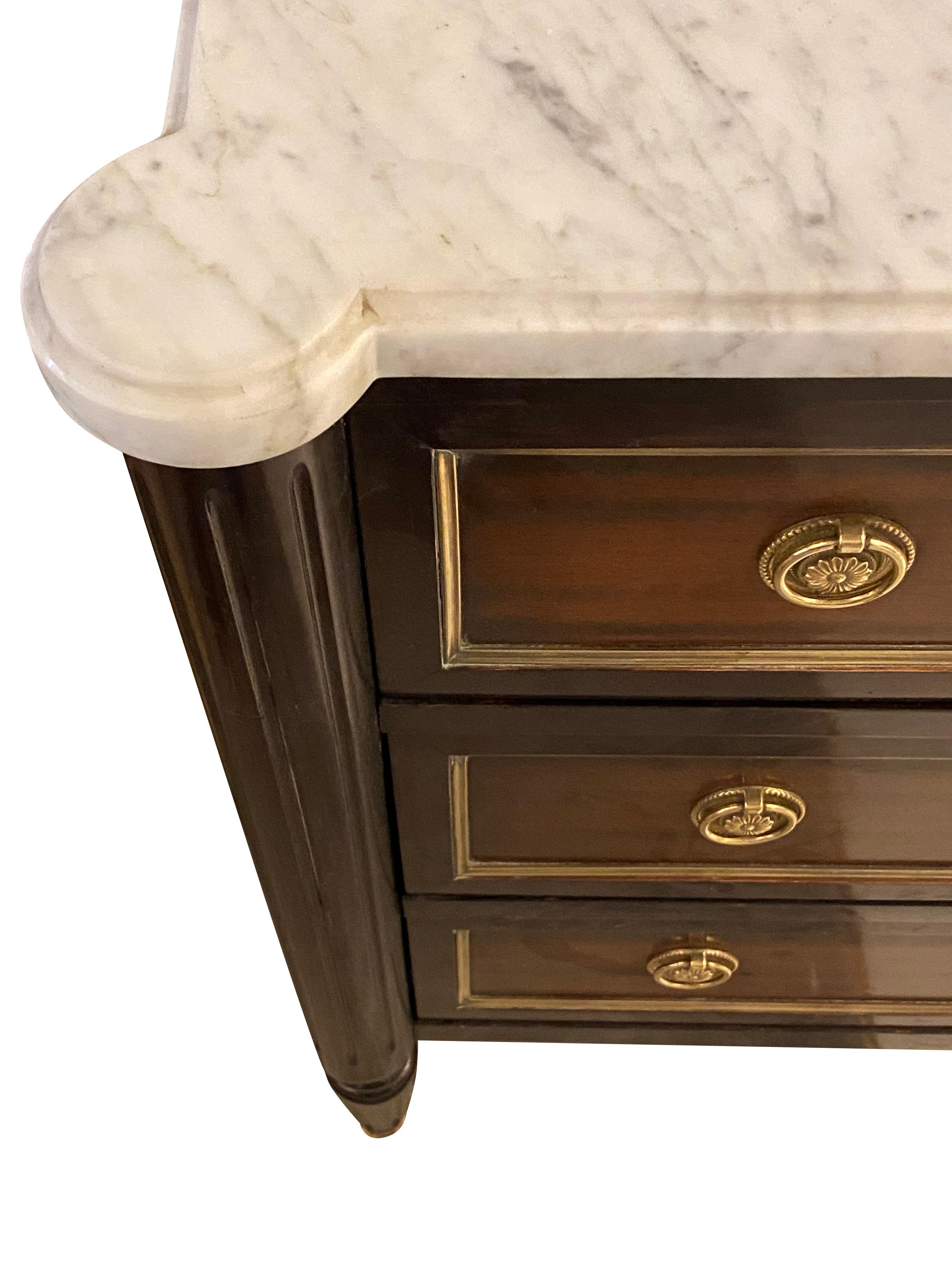 1980s French three drawer commode in the style of French Empire
Walnut with ebonized trim detailing
Carrara marble top with rounded front corners
Traditional hardware trim
Ridged front legs with sabot
Recessed gold gilt trim.
  