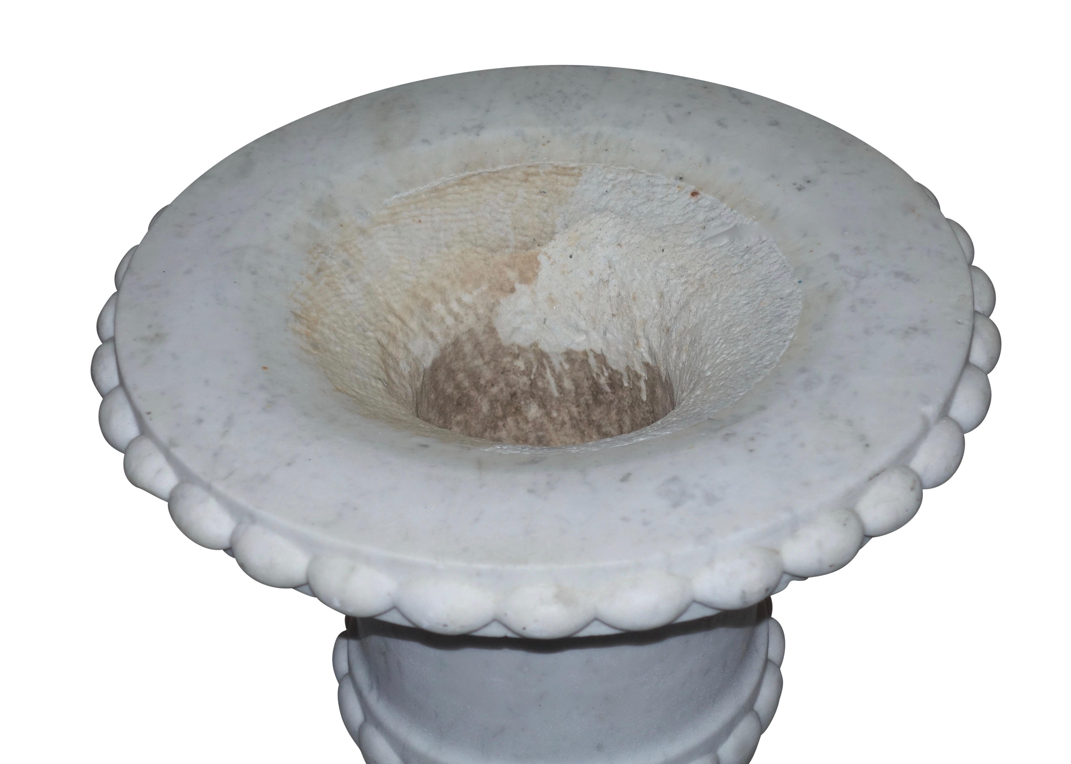 Hand carved Campagne shape white marble urn with flecks of gray. Beaded rim above tapering body with ribbed bottom sitting on a socle and plinth base, Italian, 19th century.