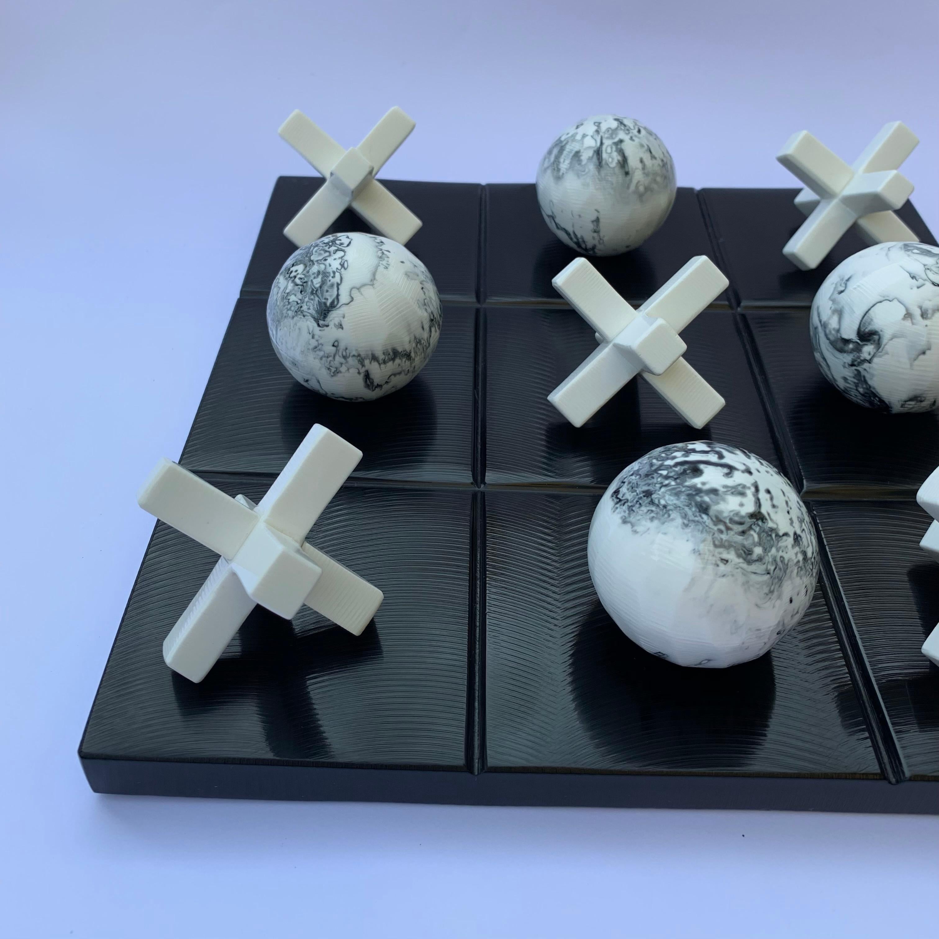 Our Tic Tac Toe is a beautiful, modern and fun take on the classic game. The three dimensional pieces are handmade in white resin with black marbled texture and the board is made of black textured resin. It will be the coolest statement piece on any