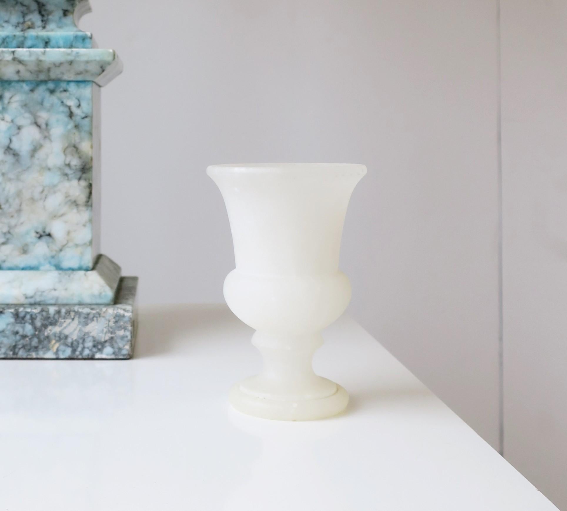 A beautiful, small snow-white matte alabaster marble urn, circa mid to late-20th century, Spain. Urn is small; Piece works as a candlestick holder (as demonstrated), or as a beautiful standalone decorative object (as shown). Piece has a matte or