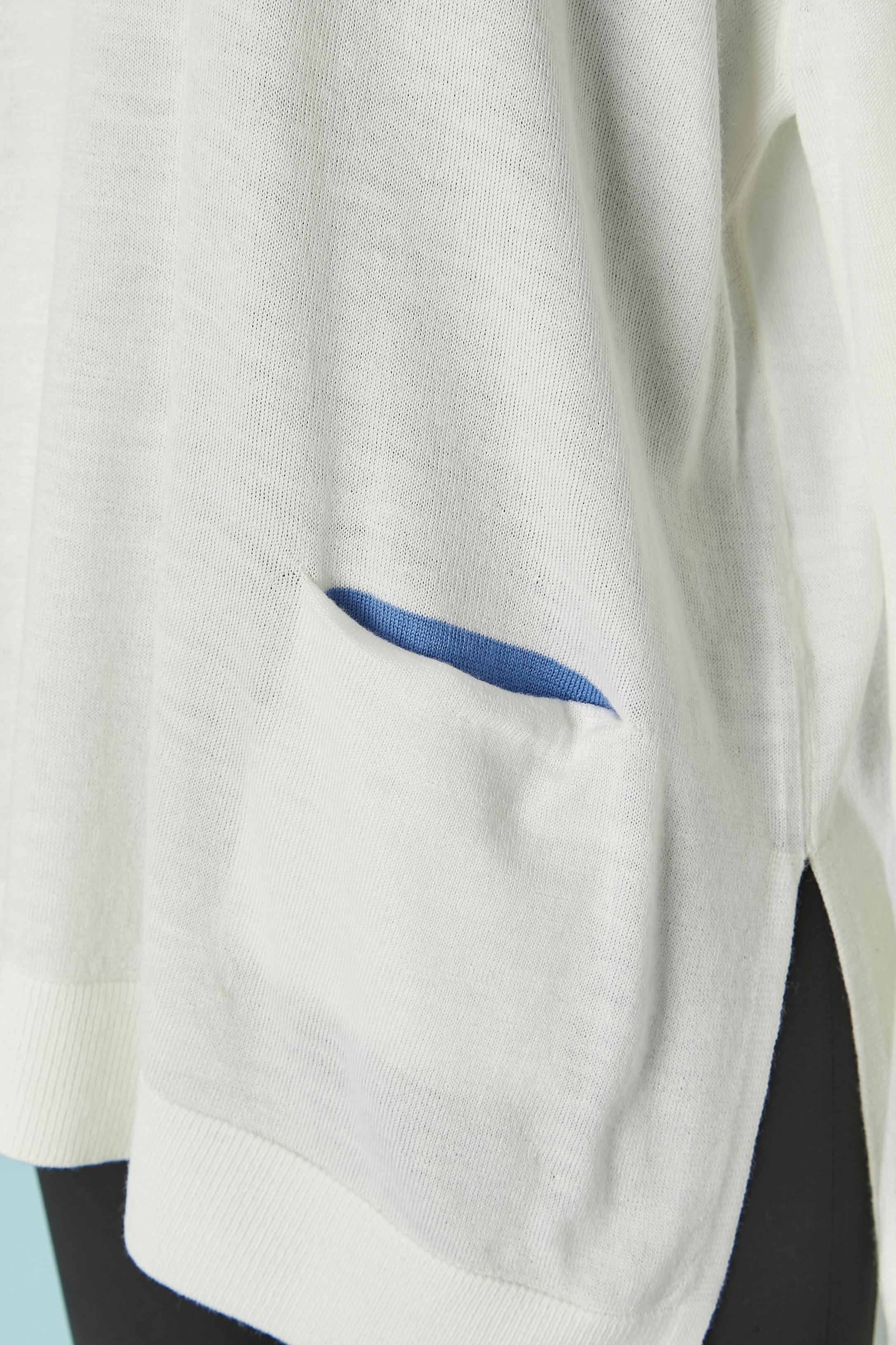 Pull en mérinos blanc avec poche sur les deux côtés et doublure bleue à l'intérieur de la poche. 
Fendu des deux côtés. 
Longueur totale sur le devant : 62cm
Longueur totale du dos : 72cm
TAILLE S ( oversize) mais convient aussi à M. 