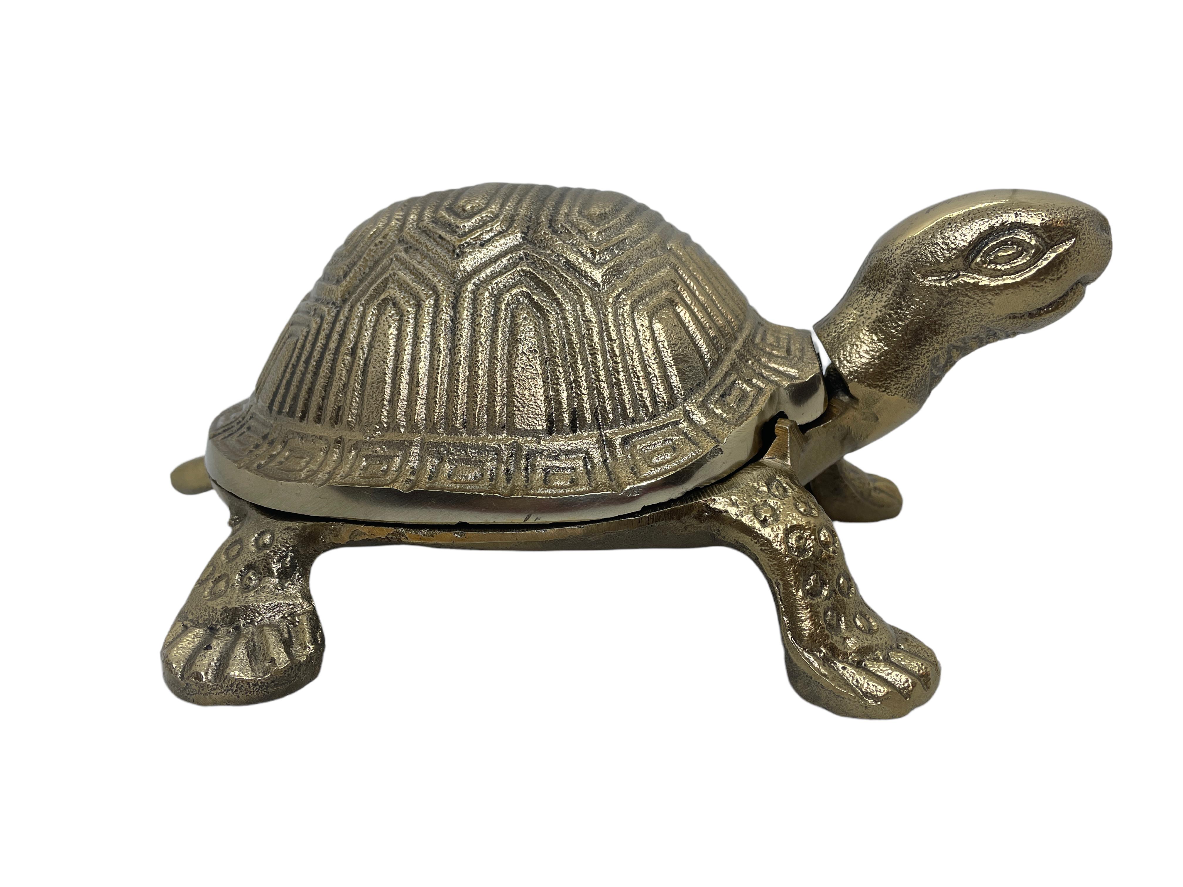 A vintage brass colored metal box in the shape of a turtle. Made probably in Austria. Beautiful detailing formed into the metal. The turtle's shell hinges open to access a shallow storage tray. Perfect for using as a jewelry box or to store office