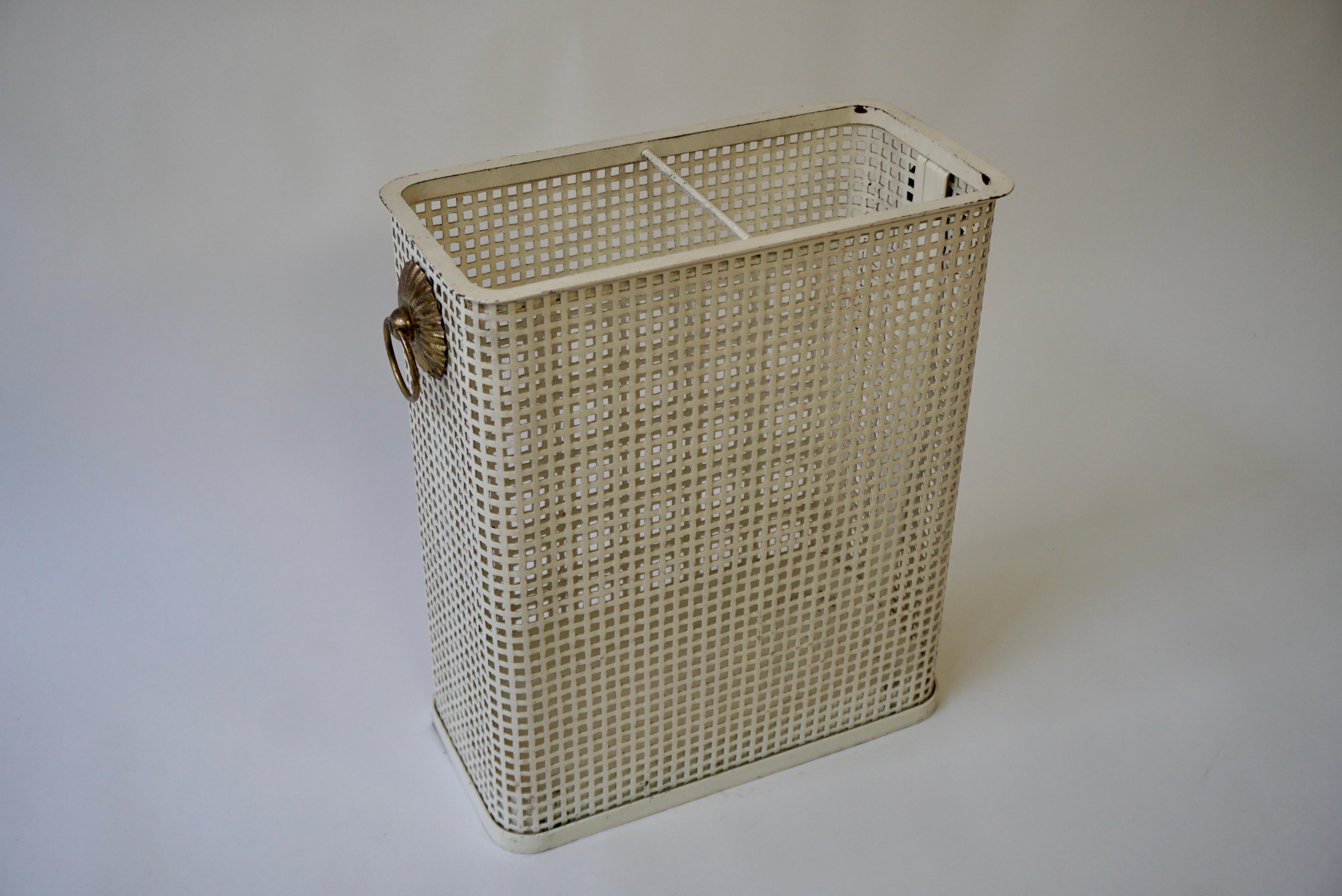 Umbrella holder or basket in a rectangular shape, in openwork metal of ivory color with a brass handle. It is in perforated white metal in the style of designer Josef Hoffmann. Time-worn patina.