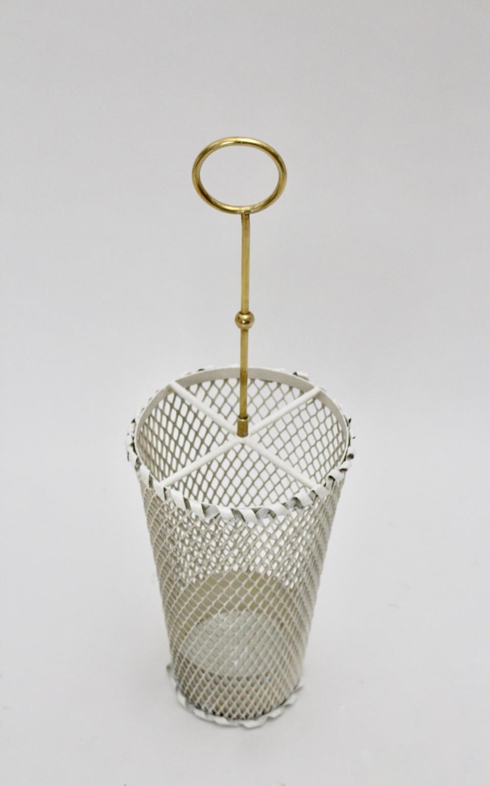 White vintage mid century modern charming umbrella stand or cane holder Design attributed to Mathieu Mategot 1950s France.
The material of the body is white enameled perforated metal, while the handle was made of brass.
This rare model showing a