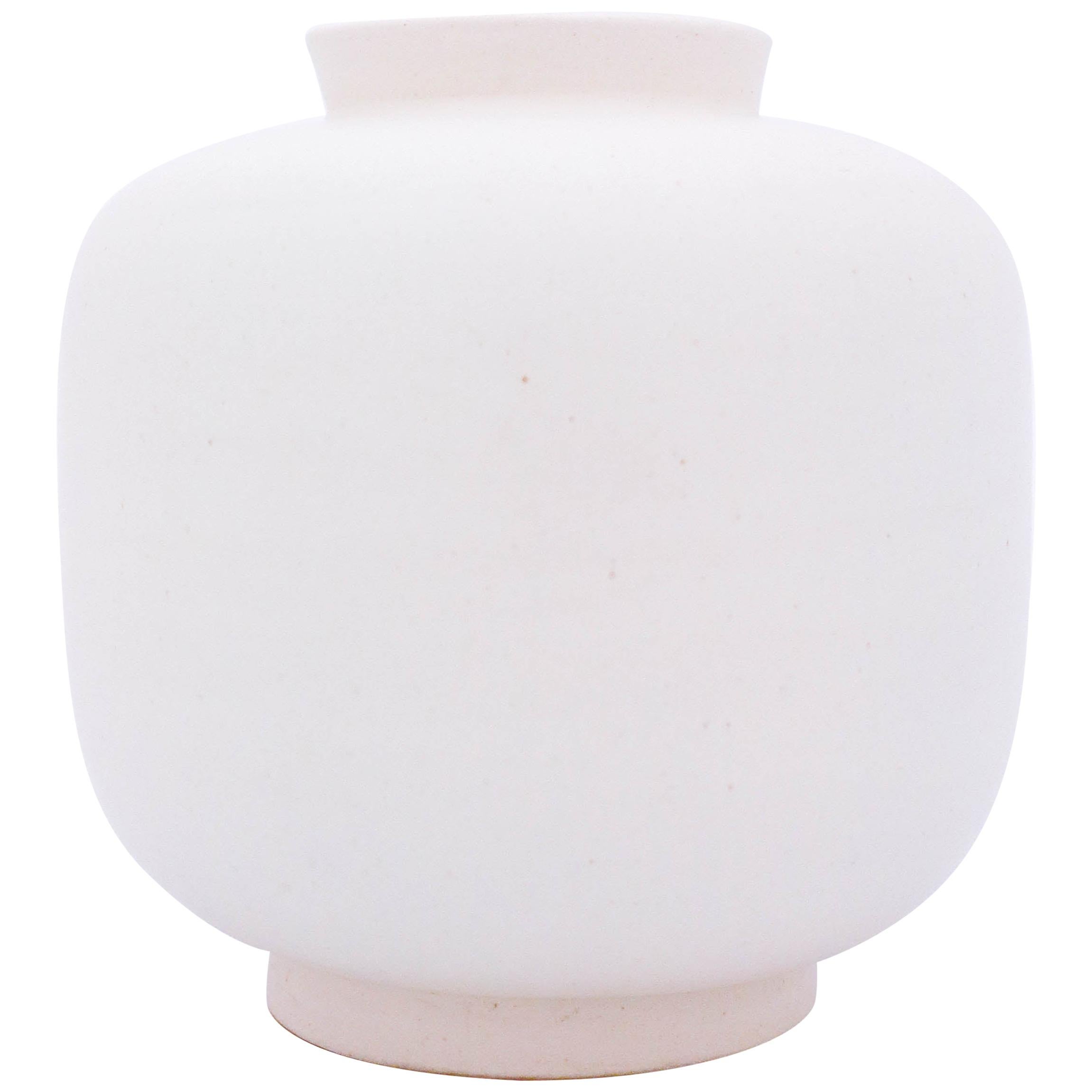 A white midcentury vase of model Carrara 1132 designed by Wilhelm Kåge at Gustavsberg. The vase has two minor marks in the glaze from the production, except from those it is in very good condition.