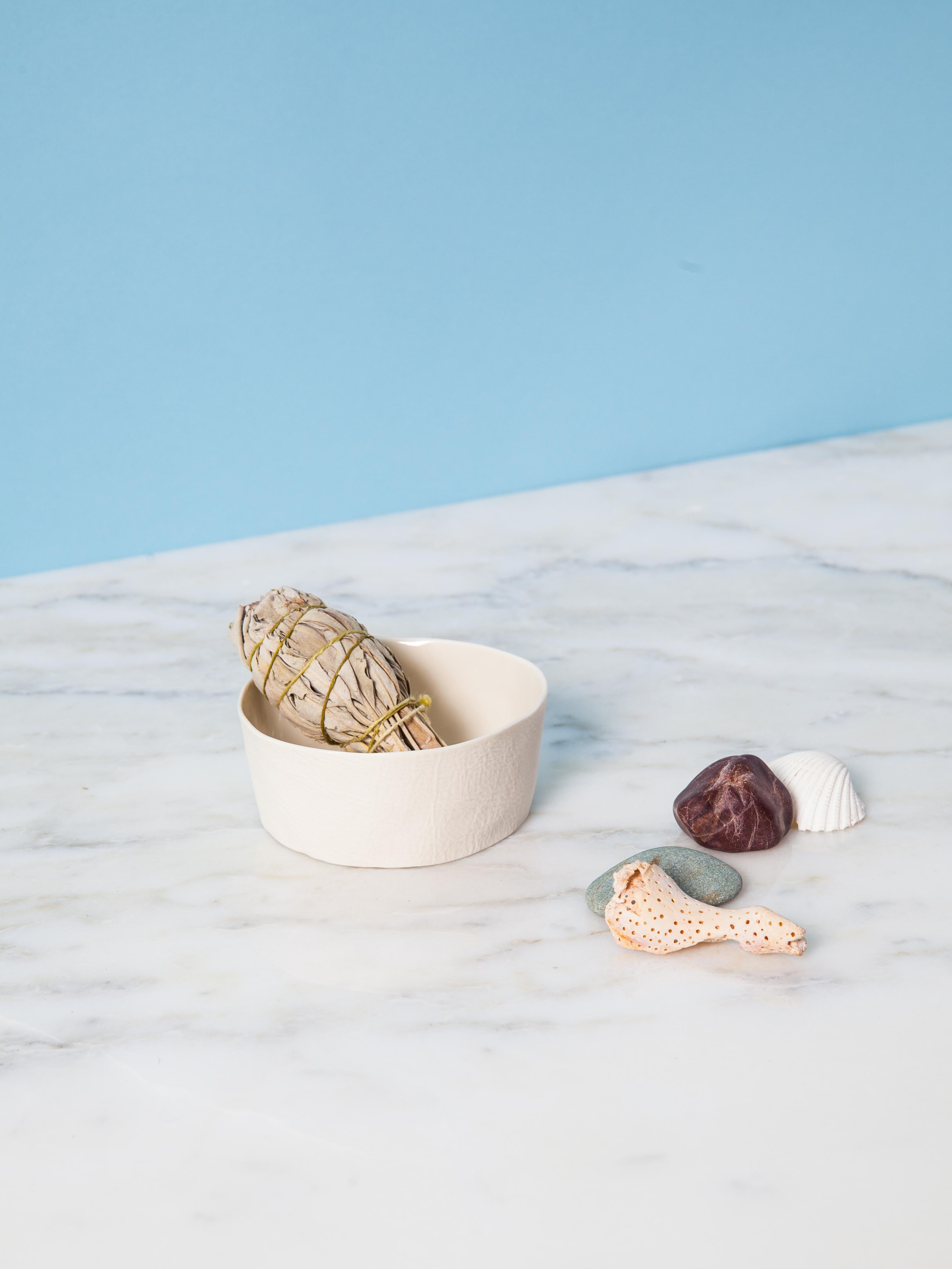 An organic shaped porcelain bowl with a tactile exterior surface and a smooth glazed interior. Small & precious, yet surprisingly practical, the Kawa Dishes are equally well-suited as a jewelry dish, salt cellar, sauces & dips bowl. As a result of
