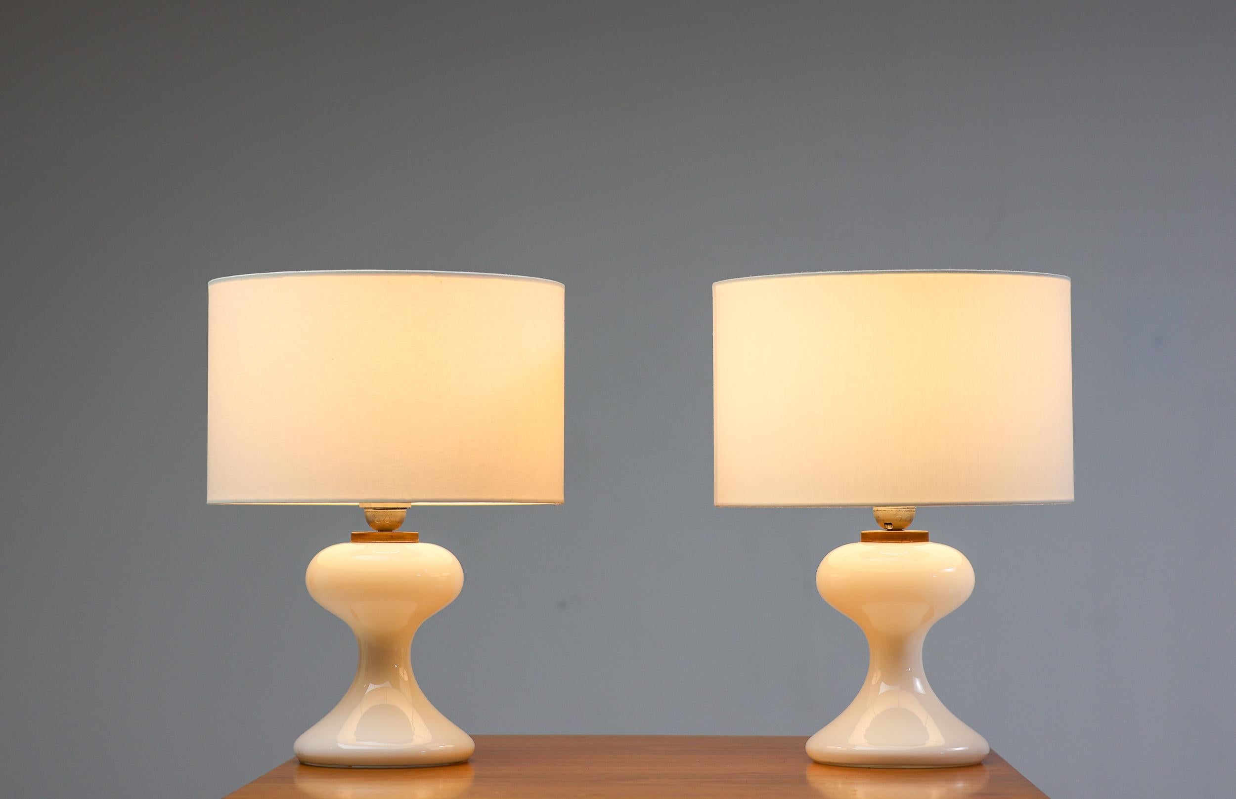 Superbe lampe de table en verre soufflé blanc avec un abat-jour en lin blanc, conçue en 1968 par Ingo Maurer pour sa société M-Design. Design très élégant qui confère une atmosphère chaleureuse à une pièce malgré son aspect moderne strict.