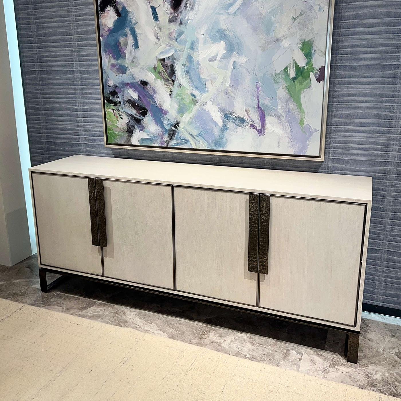 Realizzato in rovere con finitura Opal, la sua silhouette elegante è accentuata da linee d'accento sottili e verticali che aggiungono profondità e intrigo visivo. L'audace base a slitta in metallo esalta il suo fascino industriale pur mantenendo una