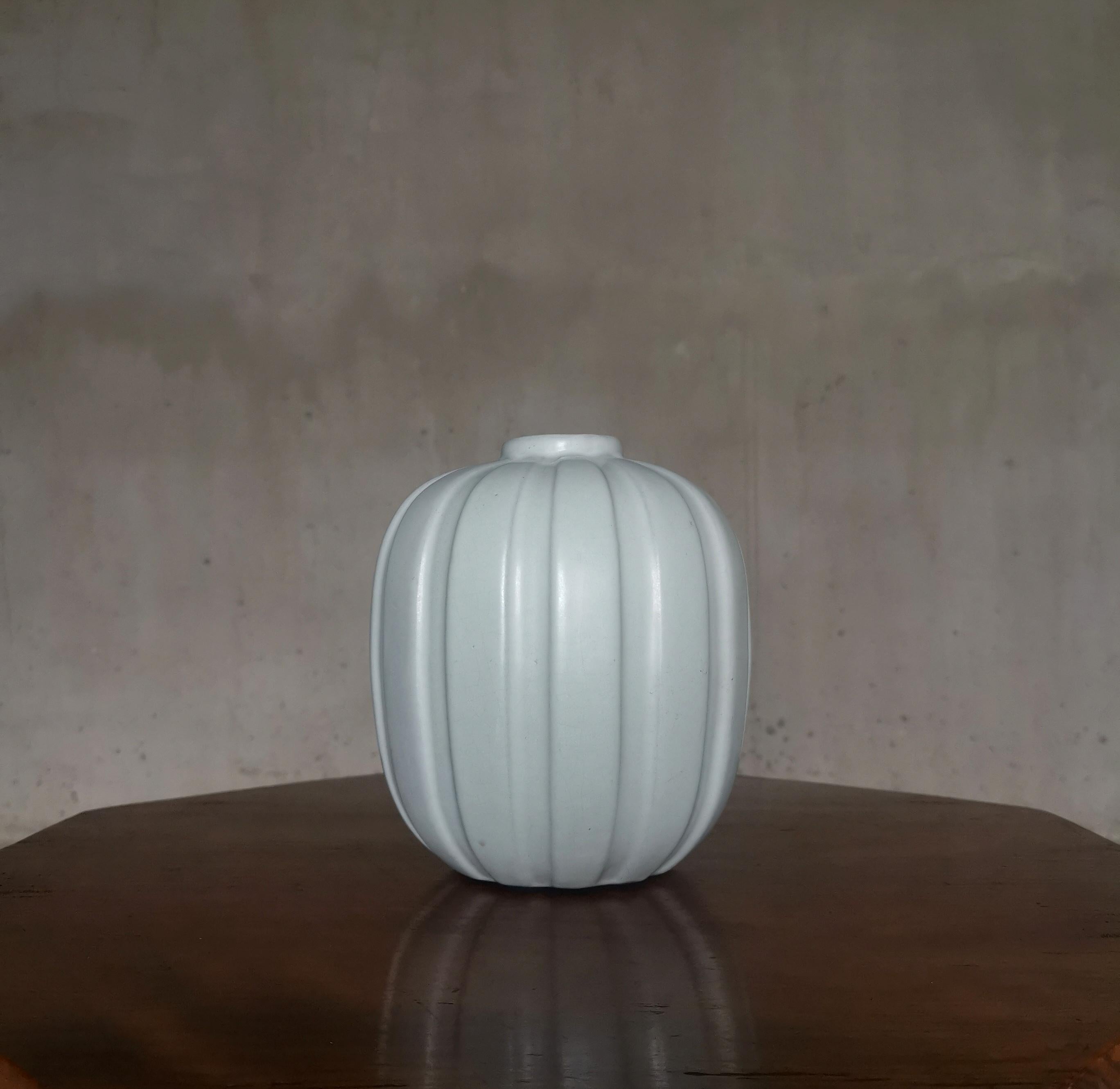 Vase en faïence blanche, cannelée et moderniste, rarement vu. 
Conçue en Suède dans les années 1930 par l'artiste suédoise Vicke Lindstrand et fabriquée par Upsala Ekeby. L'année de production est plus proche de la célèbre période suédoise de Famed,