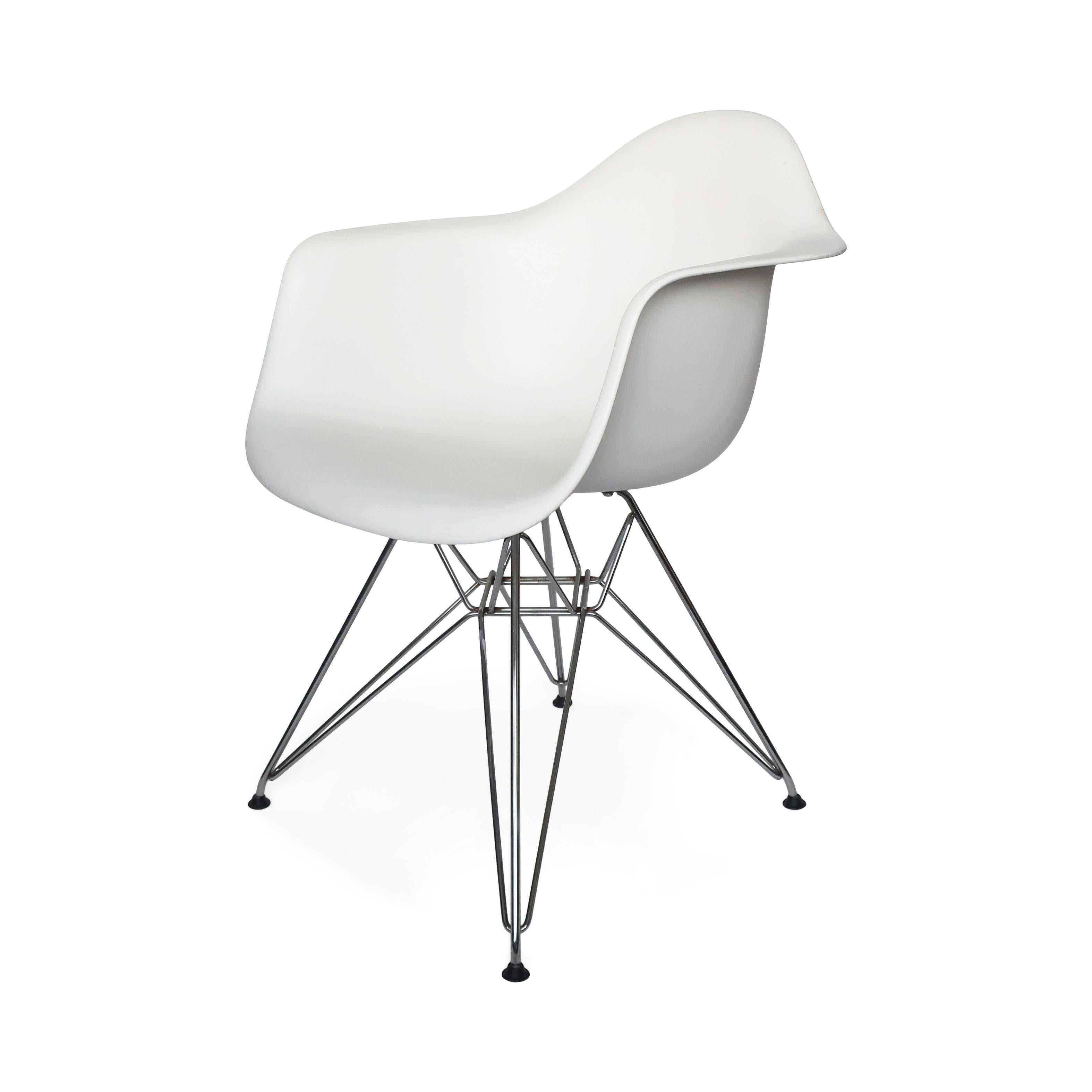 A classic molded armchairs designed by Ray and Charles Eames for Herman Miller. A white plastic chair on a chrome Eiffel base. 

In good vintage condition with wear consistent with age and use. Bears the Herman Miller and Eames logos on