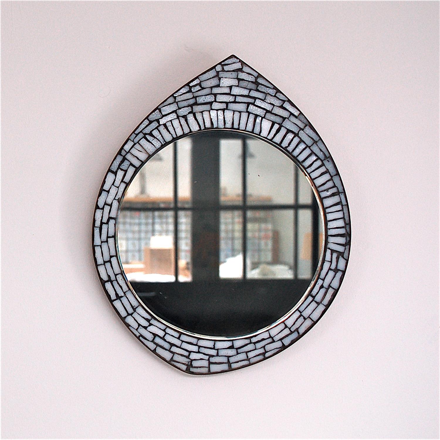 Midcentury white mosaic accent mirror in the style of Berthold Muller. The mirror has a shape that resembles a droplet, a tear drop. With the simple addition of an extra hook it can be hung horizontally to resemble an eye shape. Its dimensions are