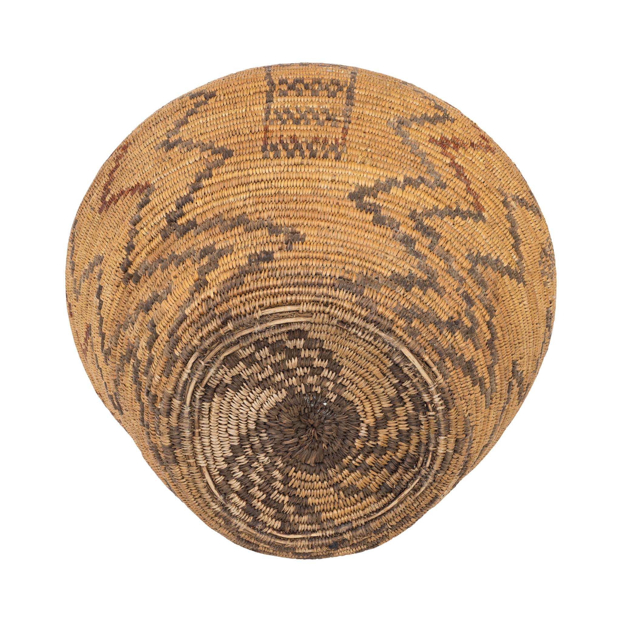Cesta de olla apache nativa americana. Olla grande con diseños geométricos de relámpagos y cajas en colores oscuros y rojos. Bien tejida y con una bonita pátina. Algunos signos de la edad y el uso. Una hermosa pieza de exposición para una colección