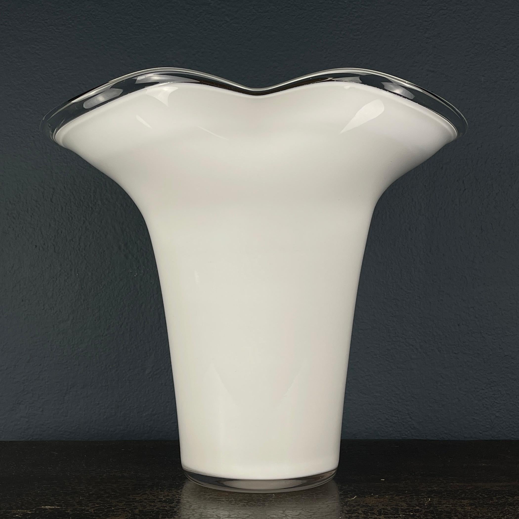 Behold this stunning white Murano art glass vase, a masterpiece meticulously crafted in Italy during the fashionable 1970s. This vase has gracefully stood the test of time and remains in remarkable vintage condition.

With its mid-century design,