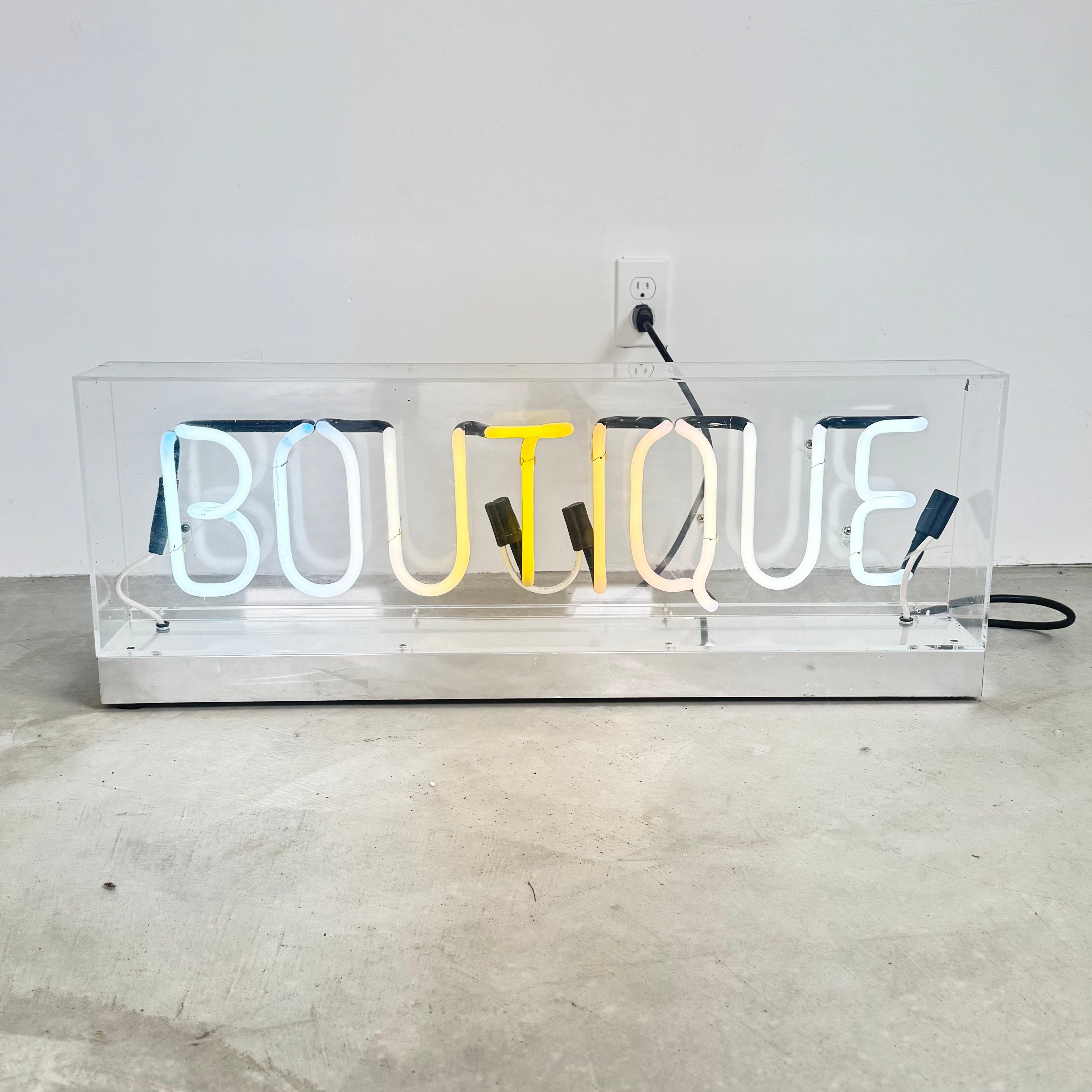 Fantastique enseigne lumineuse vintage faite à la main épelant le mot BOUTIQUE. Parfait pour un magasin, un restaurant ou un dressing ! Lettrage en néon blanc dans une boîte en Lucite. Tous les néons sont blancs, les photographies capturent le gaz