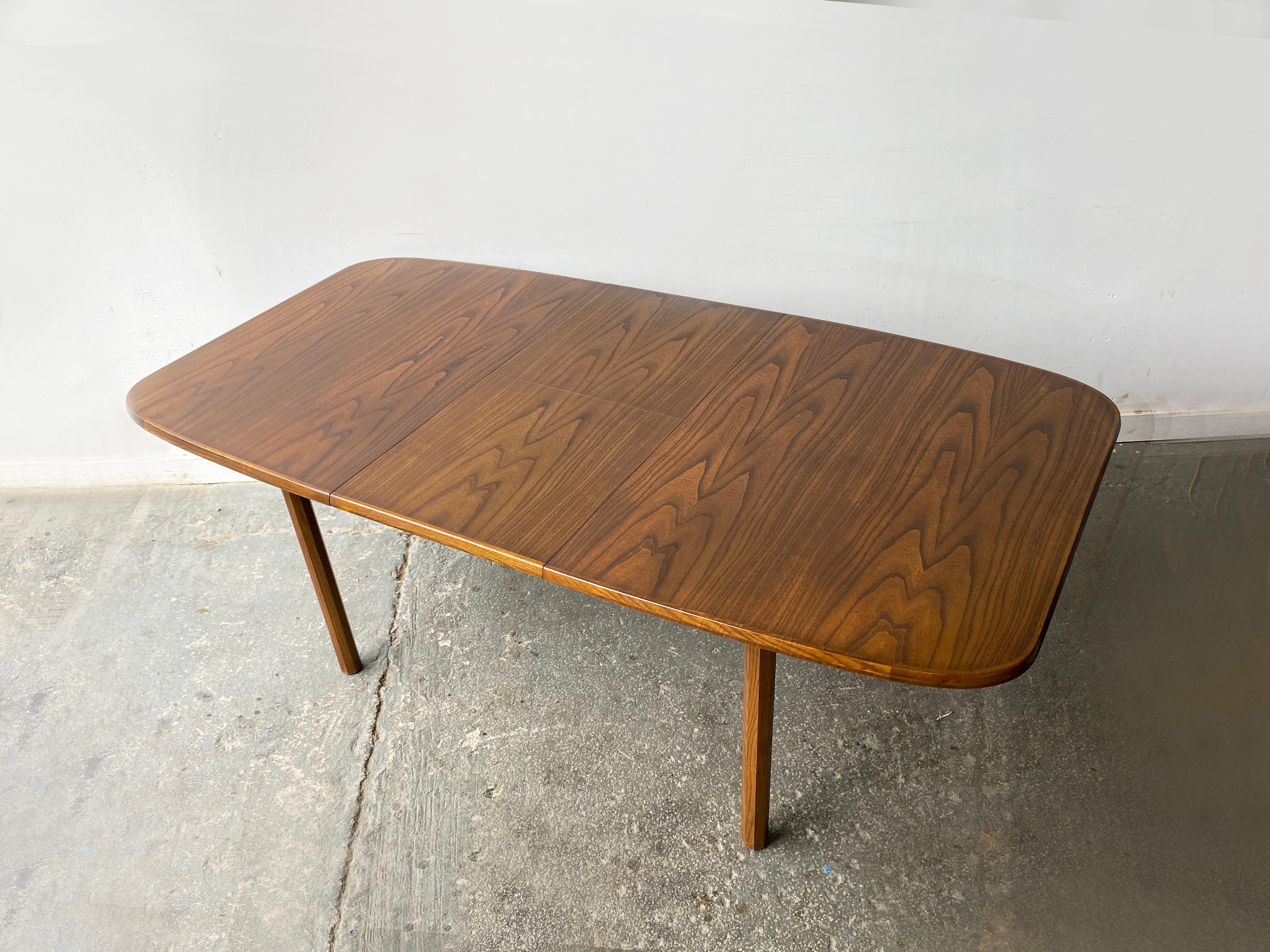 Una mesa de comedor extensible moderna de mediados de siglo de White & Newton, el respetado fabricante inglés conocido por sus diseños refinados y atemporales.

Las características de la mesa:
- Tablero de teca ricamente veteada con un llamativo