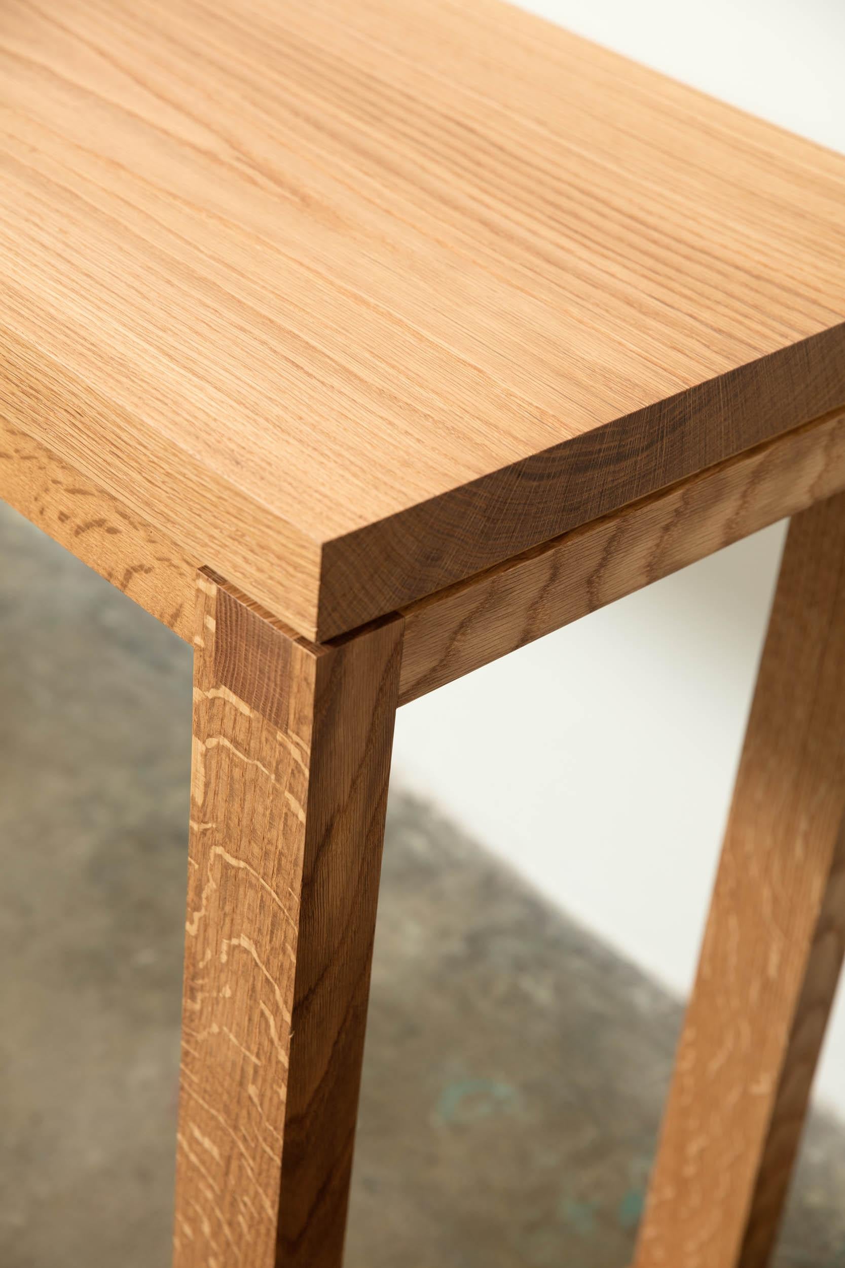 Der Mason Table ist ein moderner Konsolentisch aus Massivholz, der mit modernen Linien und unauffälligen Tischlerdetails gefertigt ist. Das schöne, urbane Hartholz aus Alabama, hier in Weißeiche, hebt sich von den anderen Einrichtungsgegenständen in