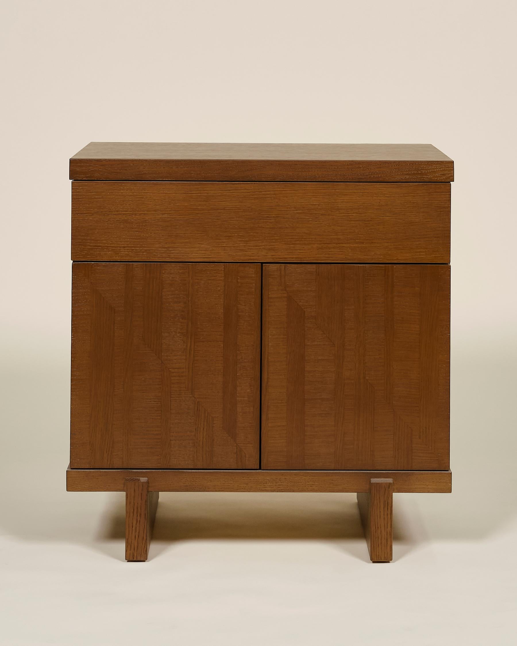 Cette table de nuit en bois personnalisé est fabriquée à la main aux États-Unis avec une construction entièrement en bois dur. Caractérisée par ses portes en marqueterie marquetée à la main et son tiroir de rangement pratique et accessible, la table