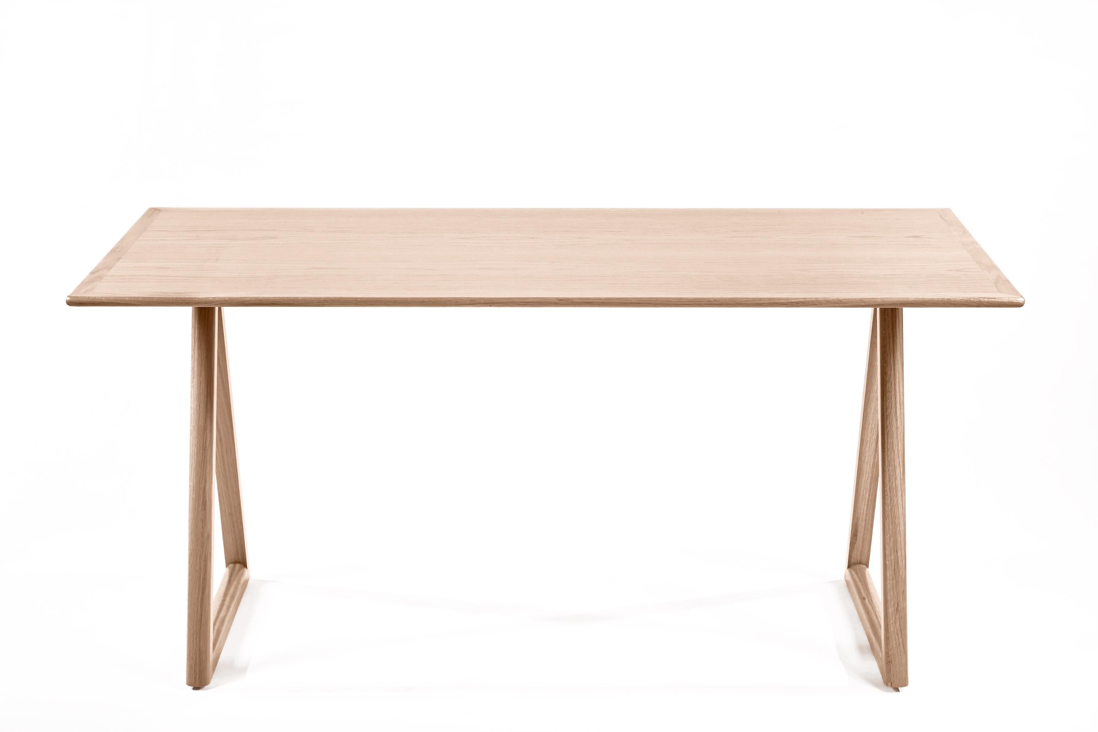 Meet our Porter Desk, showcasing modernist simplicity. This understated, piece pairs clean-lines and geometric forms. A simple, yet solid, bullnosed wooden top appears to float atop a pair of triangular-shaped supports. Bench made, in Los Angeles,