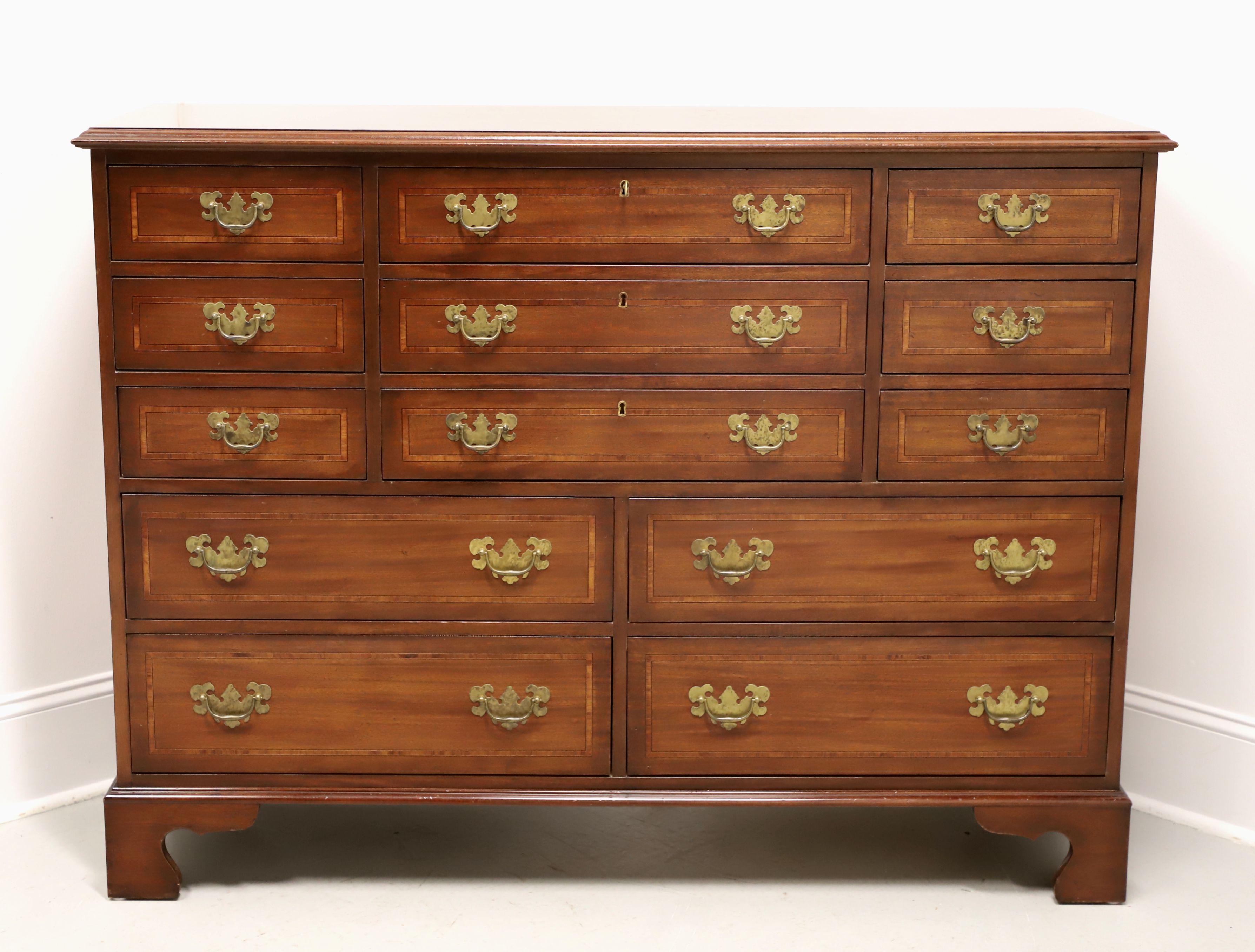 A large dressing chest in the Chippendale style by White Furniture. Mahogany with banded top & drawer fronts, slightly distressed, brass hardware, ogee edge to the top, and bracket feet. Features three lockable upper center drawers, flanked by six