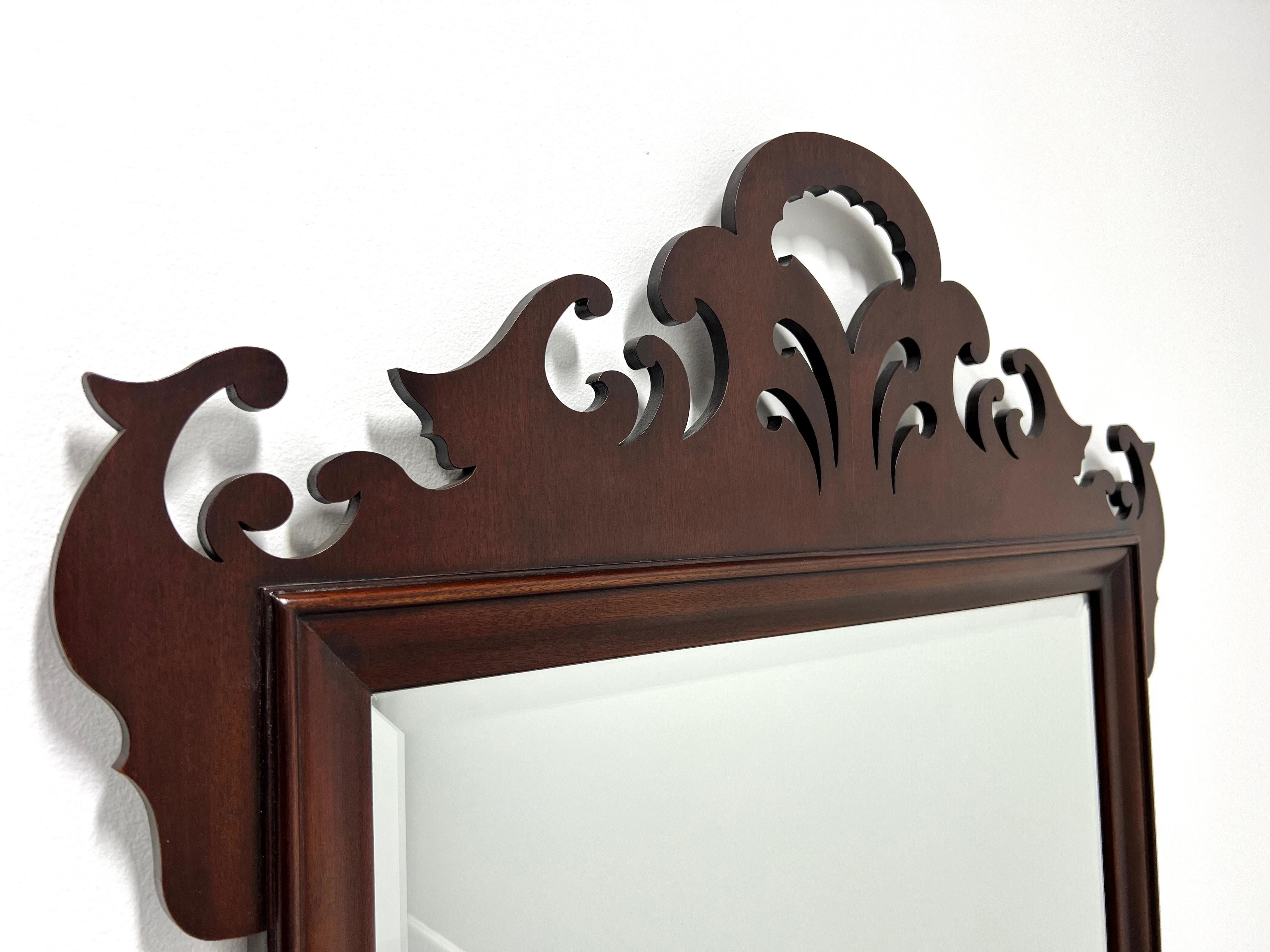 A large Chippendale style beveled wall mirror by White Furniture. Bevel edge mirrored glass, mahogany frame with decorative carving to the top and bottom. Made in Mebane, North Carolina, USA, in the late 20th Century. 

Style #: 805-42-8

Measures: 