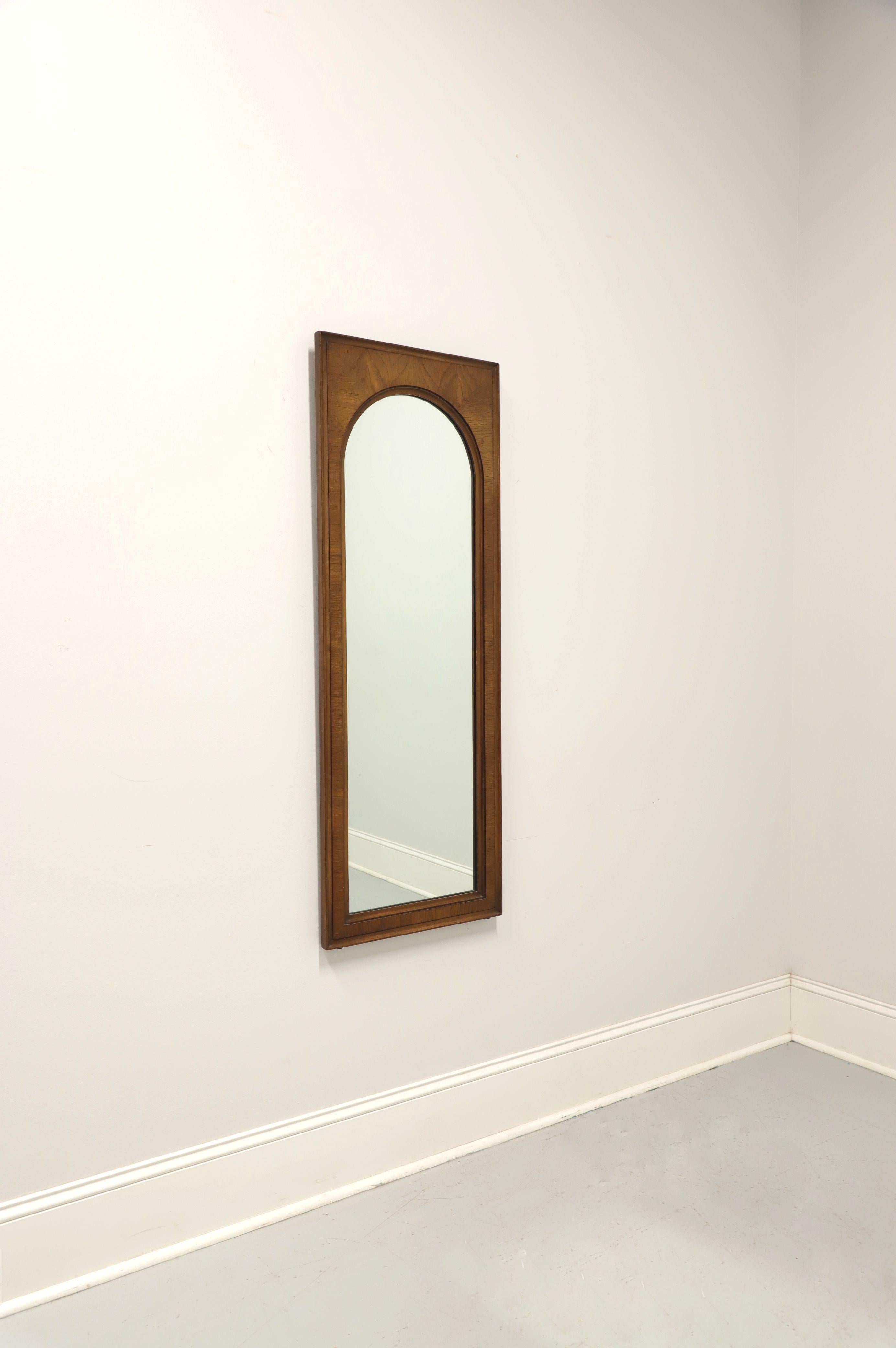 A Mid Century Modern style wall mirror by White Furniture, of Mebane, North Carolina, USA. Arched top mirrored glass in a rectangular walnut frame. Made in the mid 20th Century. 

Measures: 18W 1.25D 49.25H, Weighs Approximately: 22lbs

Very