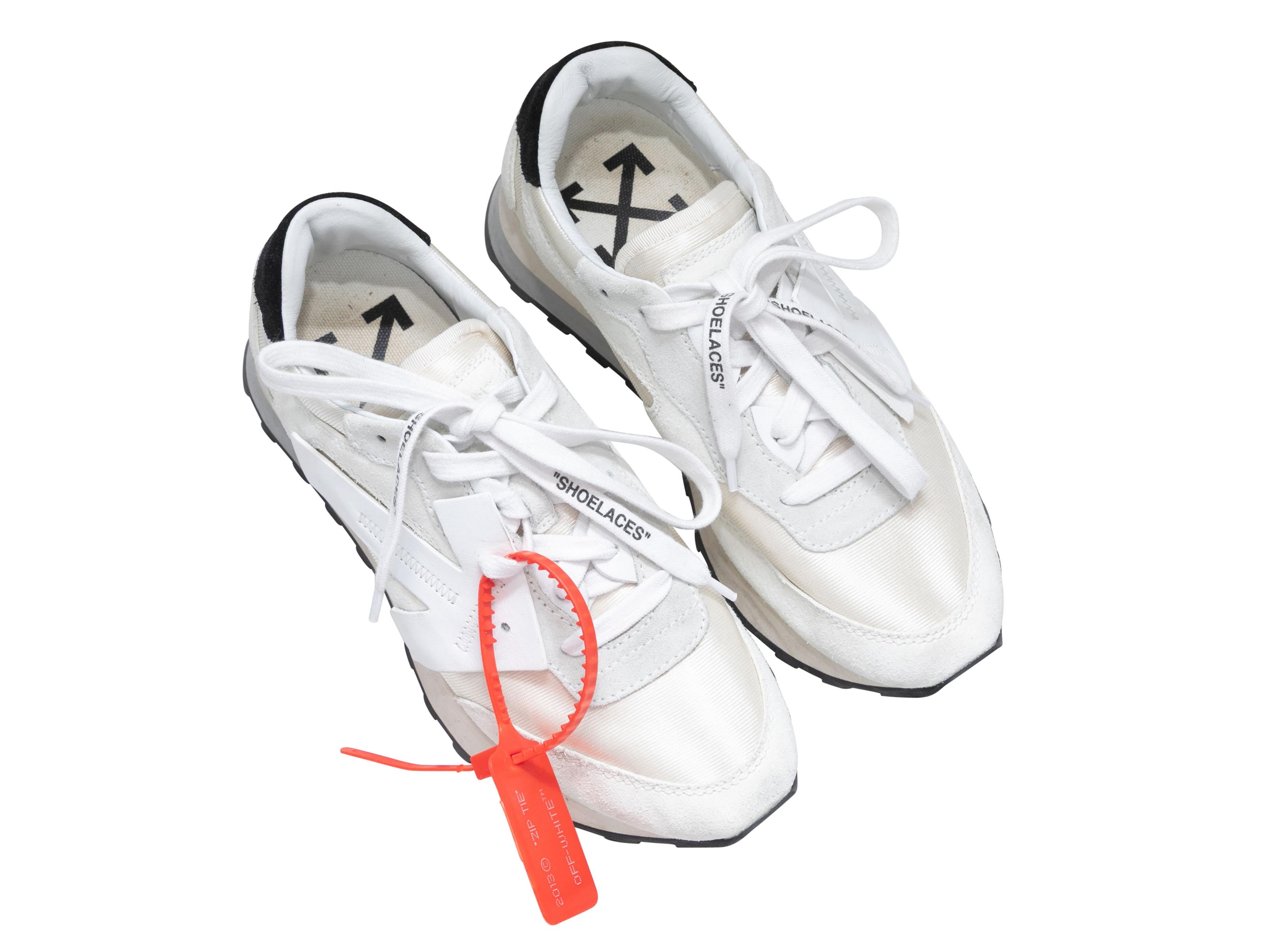 White low-top sneakers by Off-White. Foam rubber soles. Lace-up tie closures at tops. 1.25