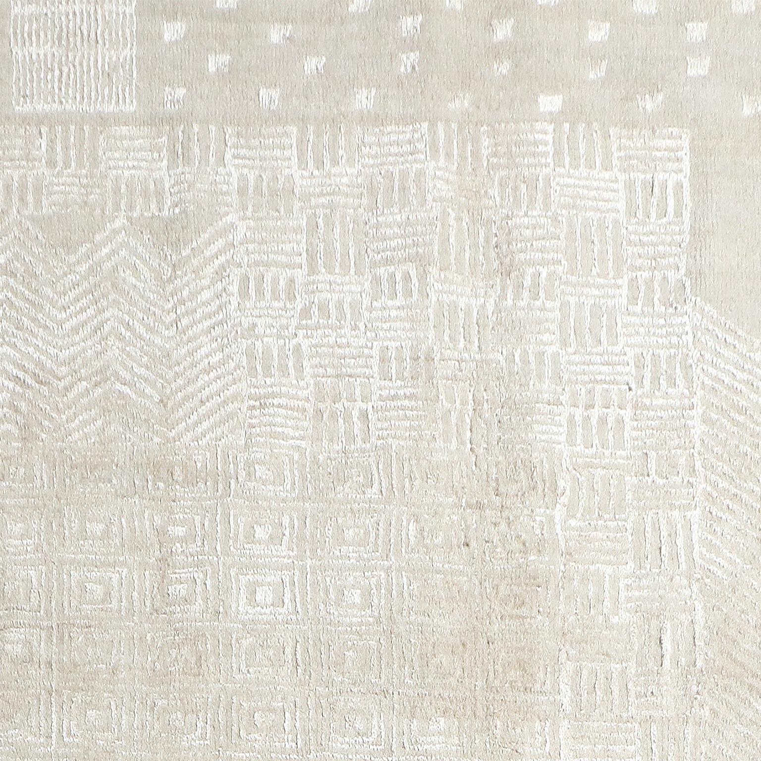This white on white carpet, sized 5' x 7', utilizes wool in the background and real silk from silkworms in the design. The tone on tone design inspired by Art Deco traditions creates a subtle overall effect while shining, both literally and