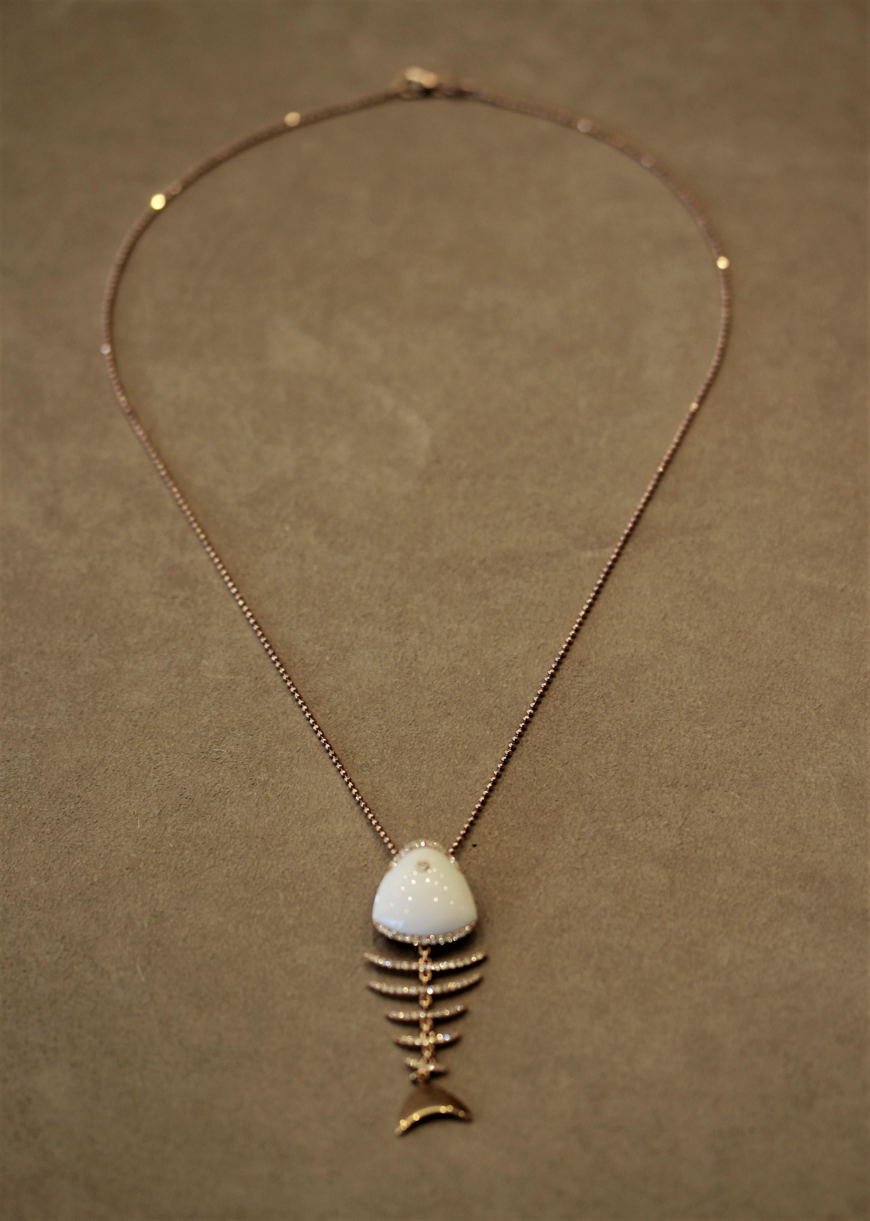 A unique fish-bone pendant featuring a piece of white onyx as the head and 1.00 carats of round brilliant cut diamonds set along the “bones” of the deceased fish. Each of the 18k rose gold bones are attached by independent links allowing them to be