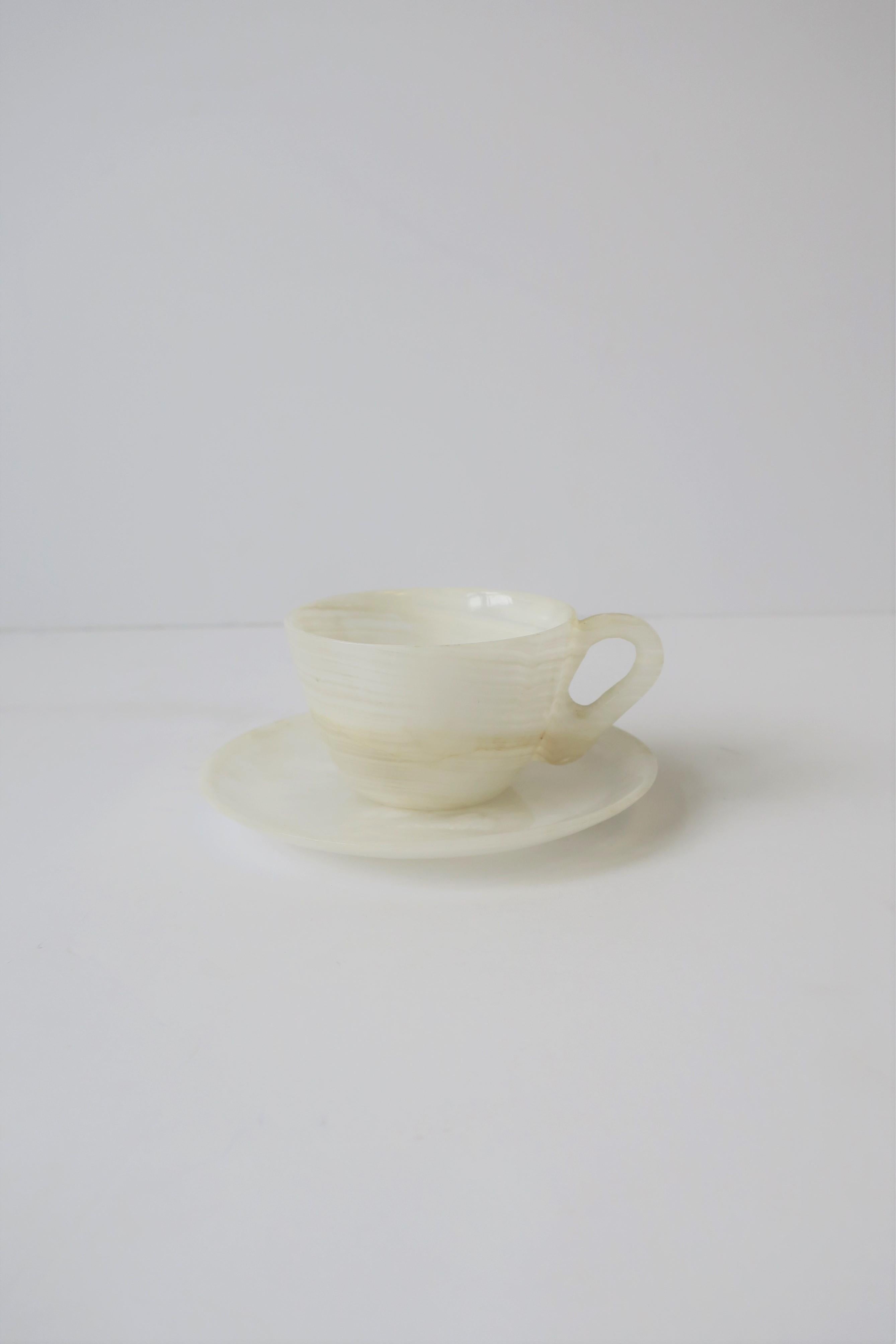 A beautiful Italian white onyx espresso coffee or tea demitasse cup and saucer set, circa 20th century, Italy. Cup and saucer are each made from a single piece of onyx; carved and polished smooth. Colors include: Predominantly white with small