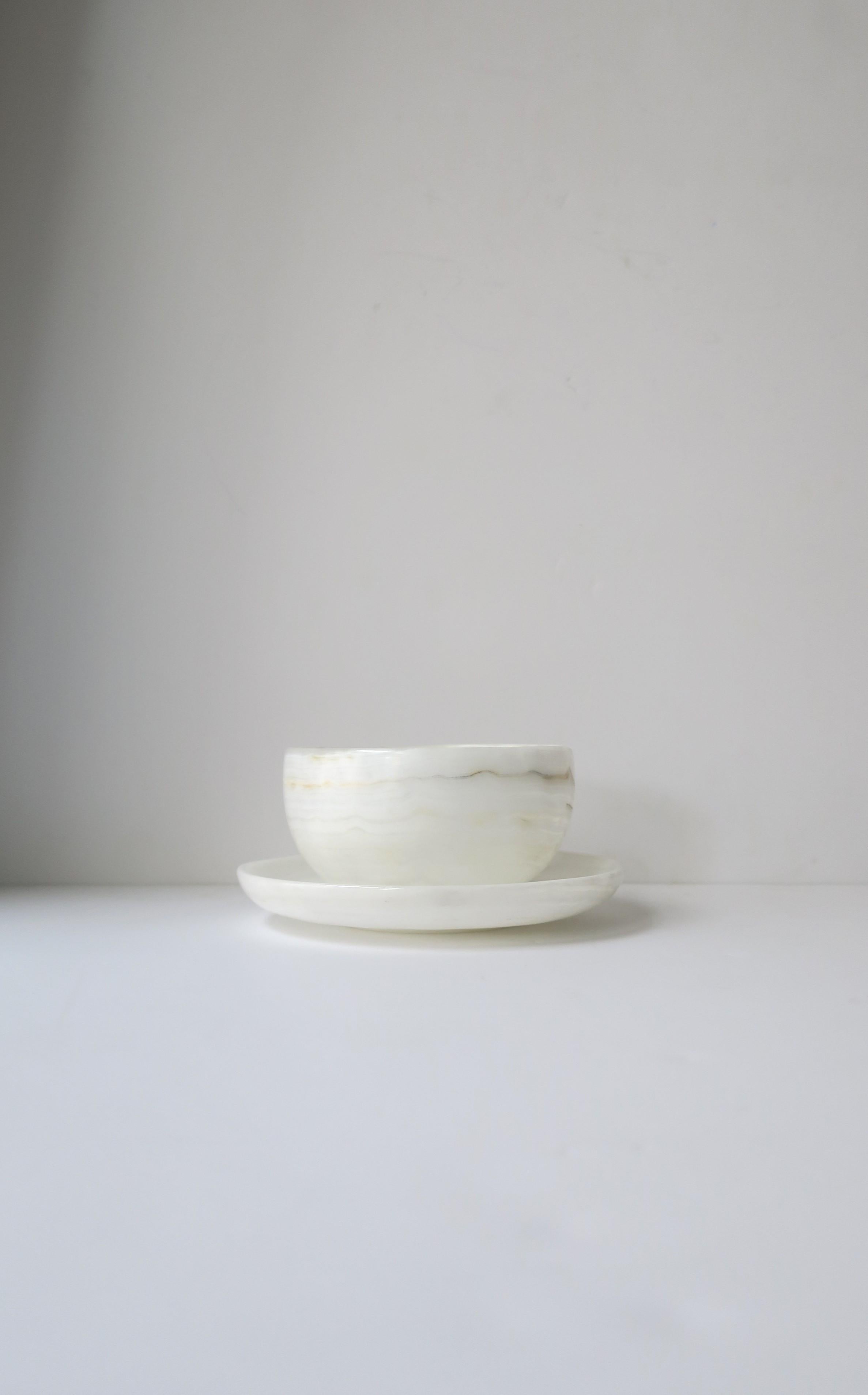 A beautiful white onyx marble bowl and saucer set in the minimalist style, circa 21st century. Onyx marble is predominantly white with traces of neutral tones as shown in images. Great as a standalone piece, to enjoy every day, or for entertaining