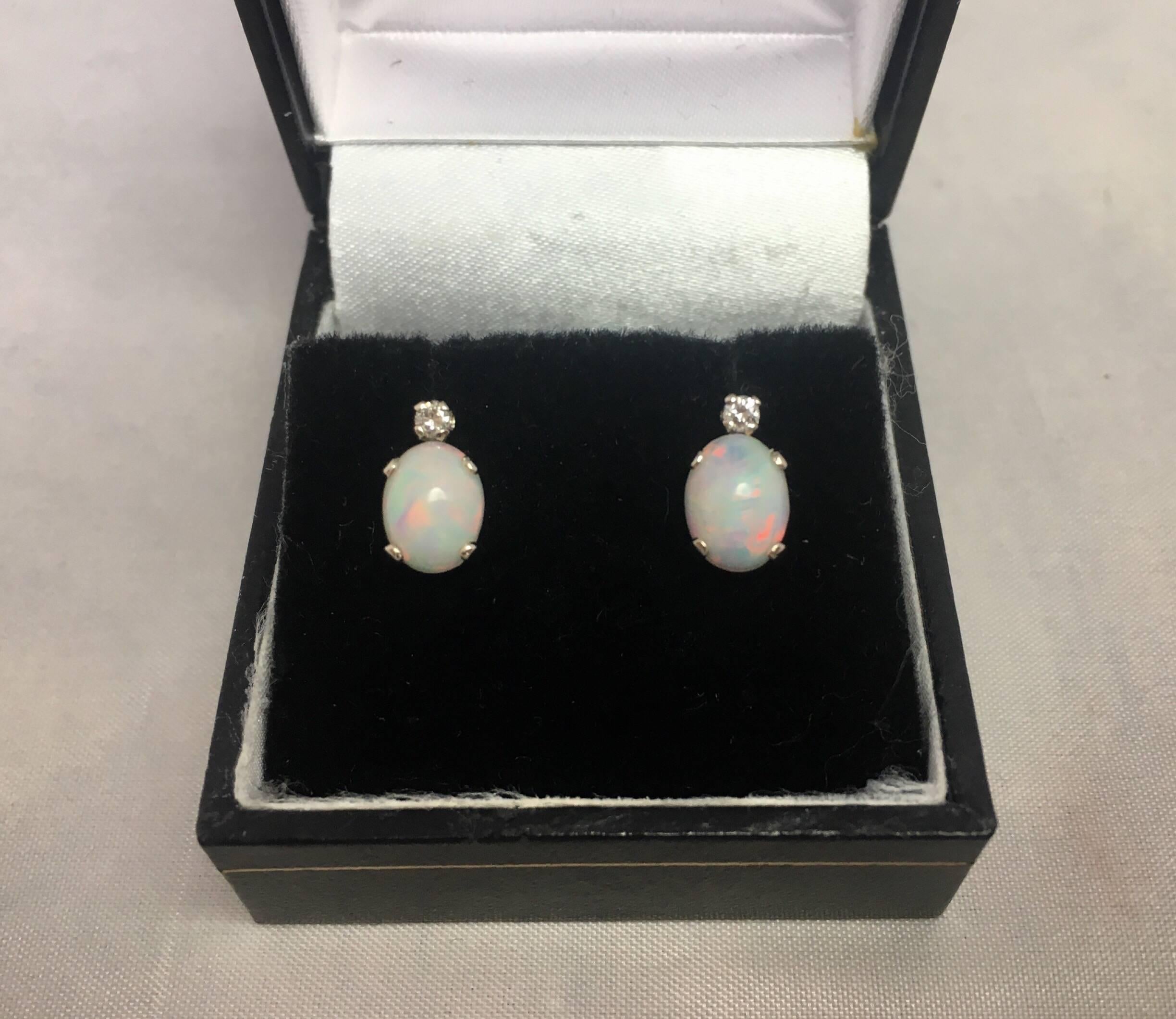 Fine natural white opal pendant and earring set with diamond accents.

The pendant is set with a 1.46 carat white opal that measures 9x7mm with a diamond accent.
The earrings are set with two 0.70 carat (1.40tcw) white opals measuring 7x5mm with