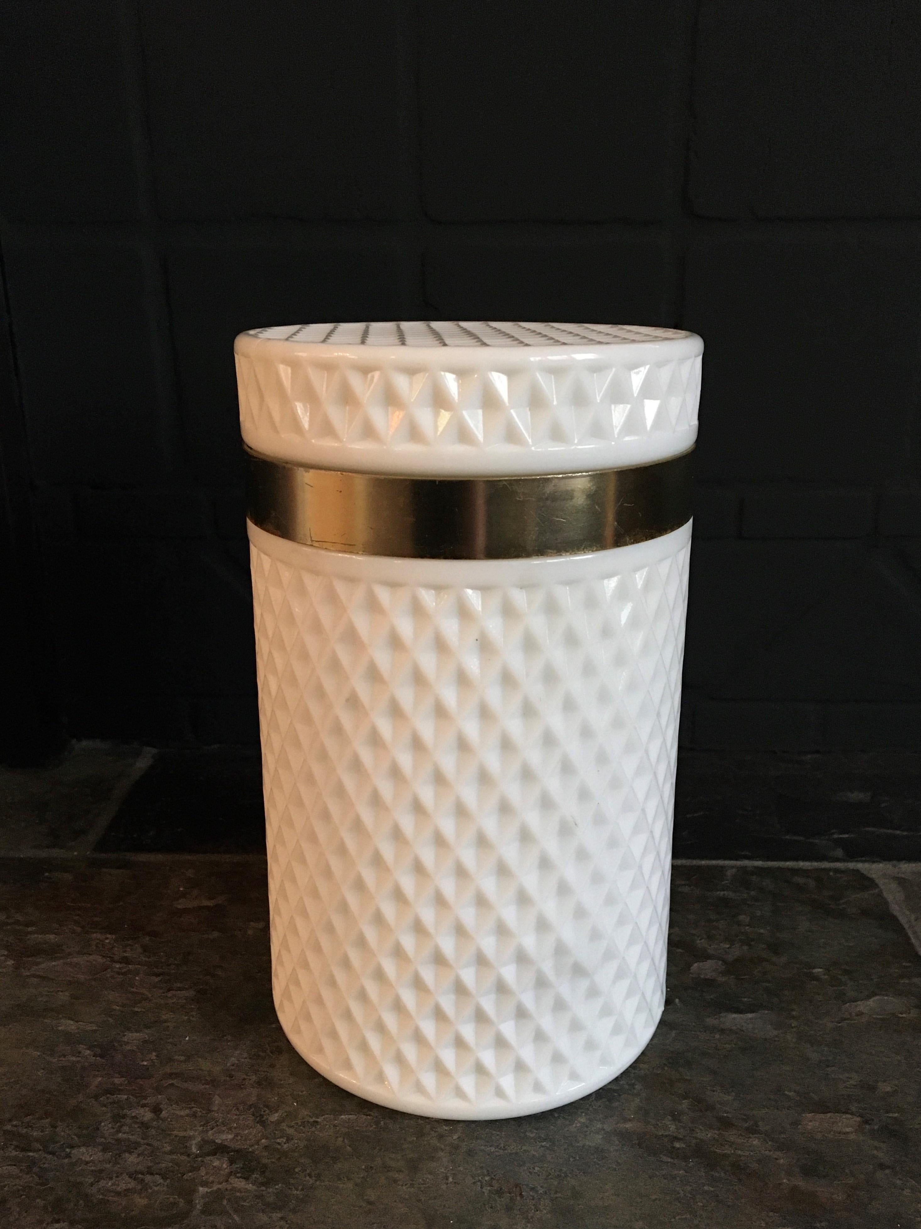 Stylish white opaline glass box. 
This white opaline pot has a diamond cut pattern all around and on the lid. 
It it round shaped - tube shaped - cilinder shaped with a gold metal ring around. 
The white glass is still very beautiful without any