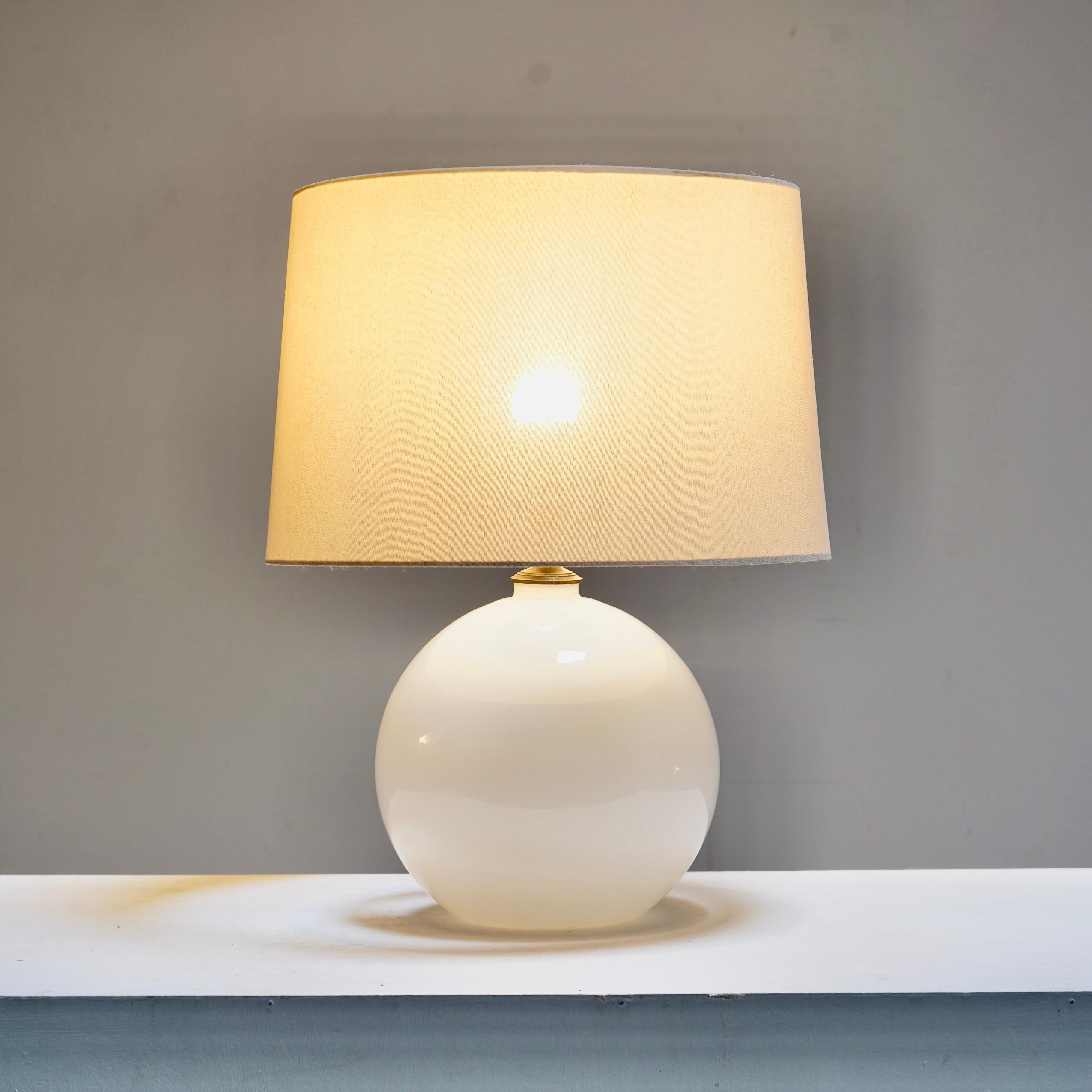 Lámpara de sobremesa de cristal opalino blanco, francés. 
Recableado y prueba PAT.
La pantalla no está incluida. 
 
Dimensiones
 
H 34 cm (hasta la parte superior de la luminaria), D 22 cm (aprox. en el punto más ancho)
 
Quiénes somos  
Somos