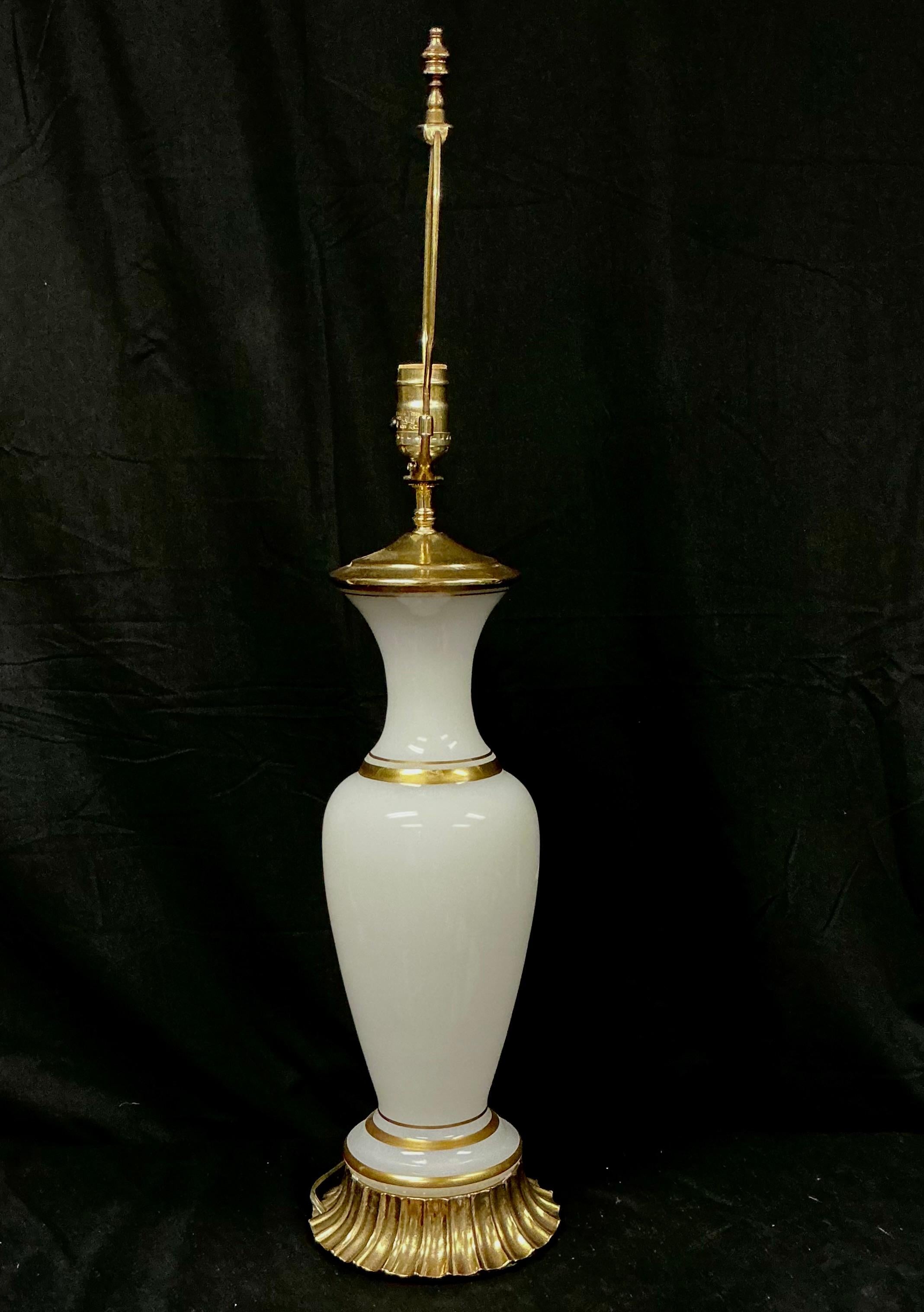 Lámpara de sobremesa de cristal opalino blanco y latón dorado de la Regencia de Hollywood de mediados del siglo XX, hacia 1950. La lámpara tiene un elegante cuerpo en forma de balaustre alargado de cristal opalino blanco, célebre por su suave