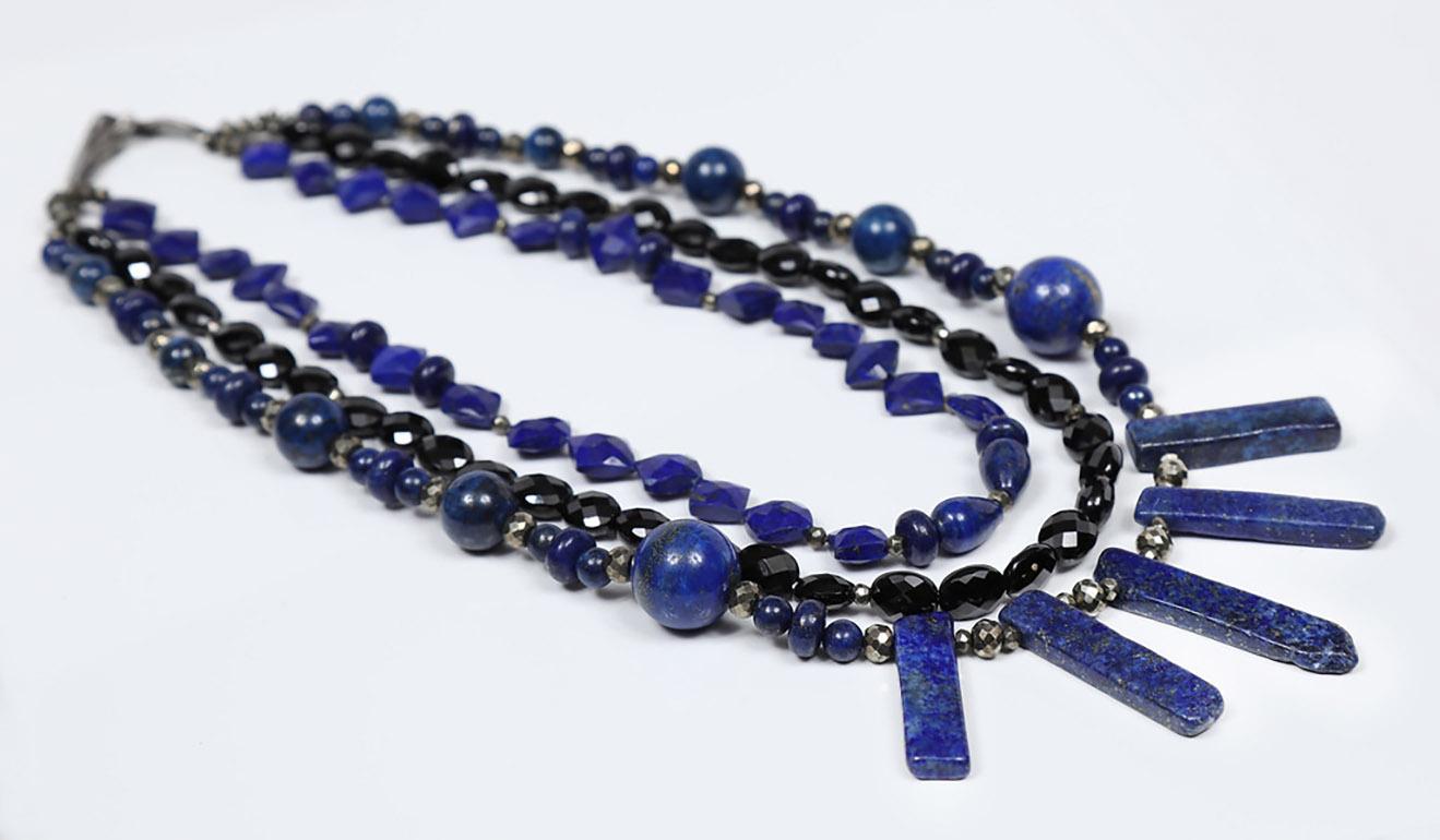 A dramatic, three-strand bib of seven sizes and shapes of lapis lazuli (from 6 to 16mm) and black spinel faceted ovals invokes a unique and ancient vibe.  This bib is completed by our White Orchid Studio artisan vanilla bean clasp in 925 antiqued