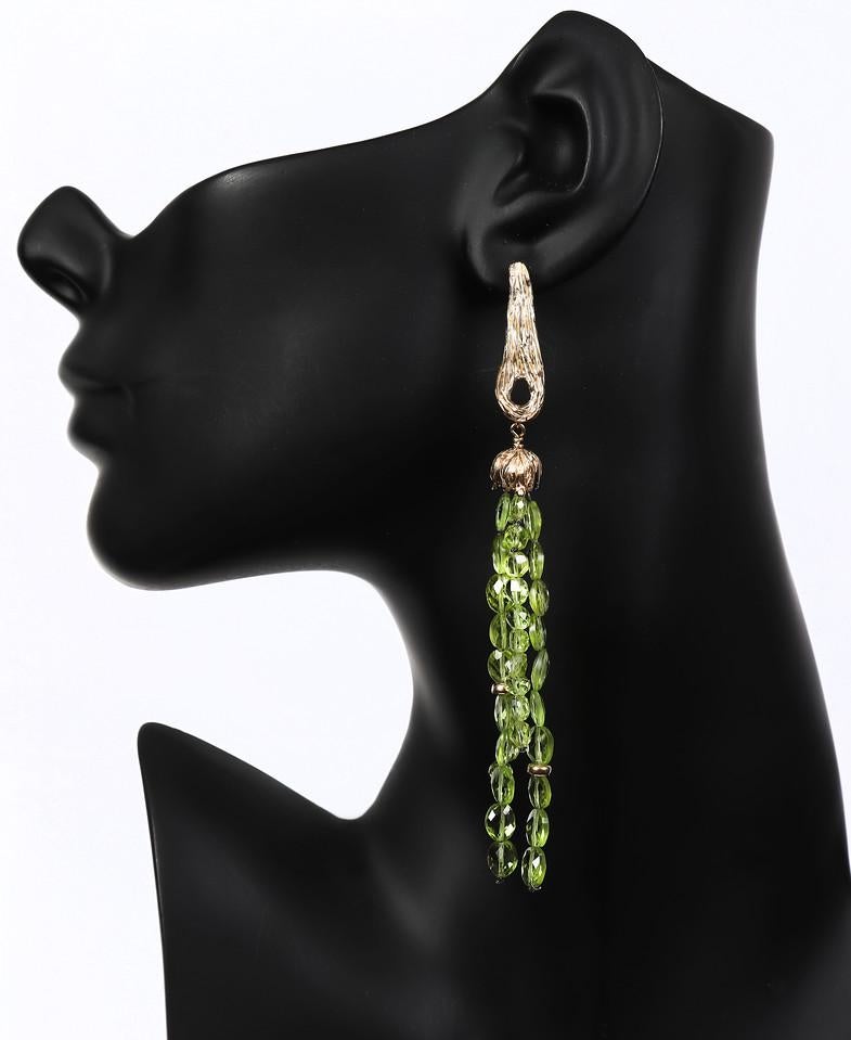 Our studio's vanilla bean pod earring begins a long cascade of peridot and gold.  All gold 14kt.  An approximate 4