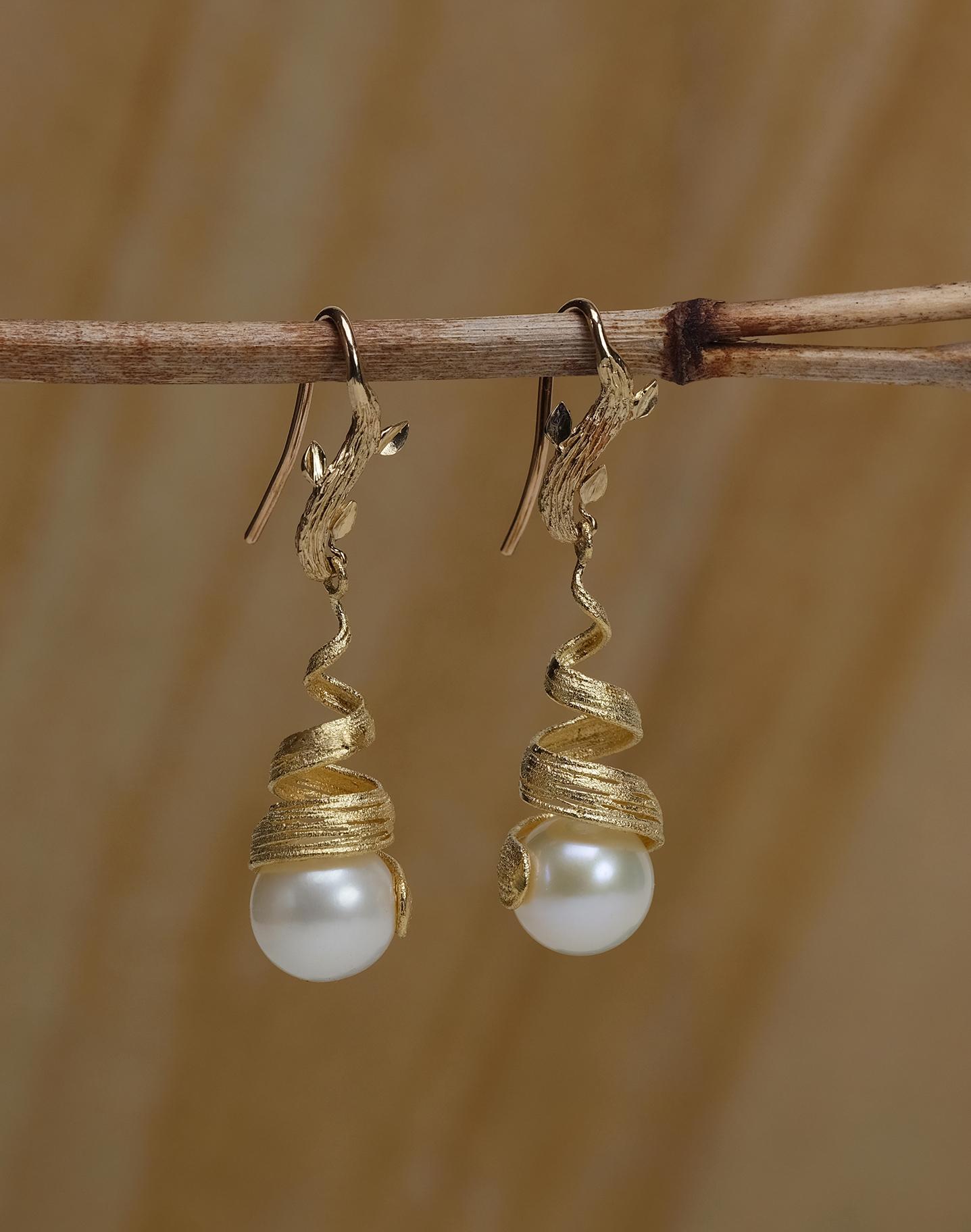 A textured gold ribbon embraces a freshwater pearl as it gently swings from White Orchid Studio's vanilla bean leaf.  All gold is 14kt.  A drop of approximately 2